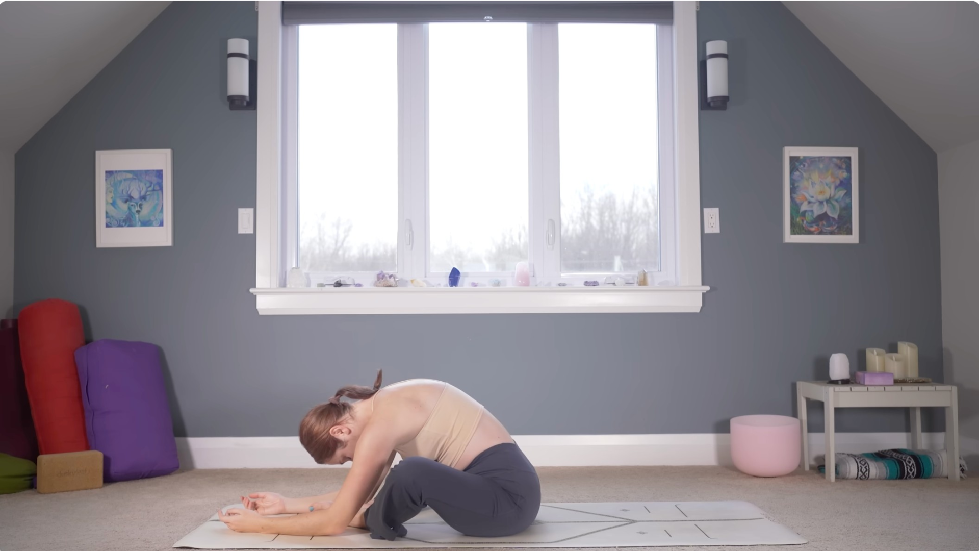 Woman sitting on a mat and leaning forward in a Bound Angle Pose