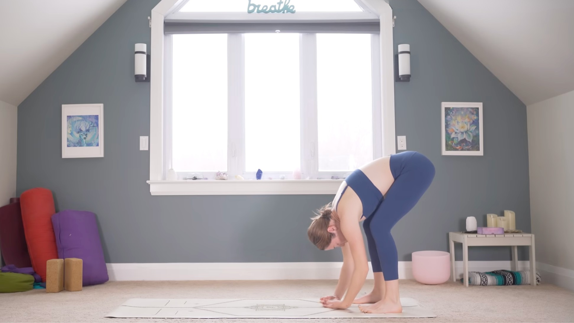 Woman standing in a forward bend with her chest toward her thighs