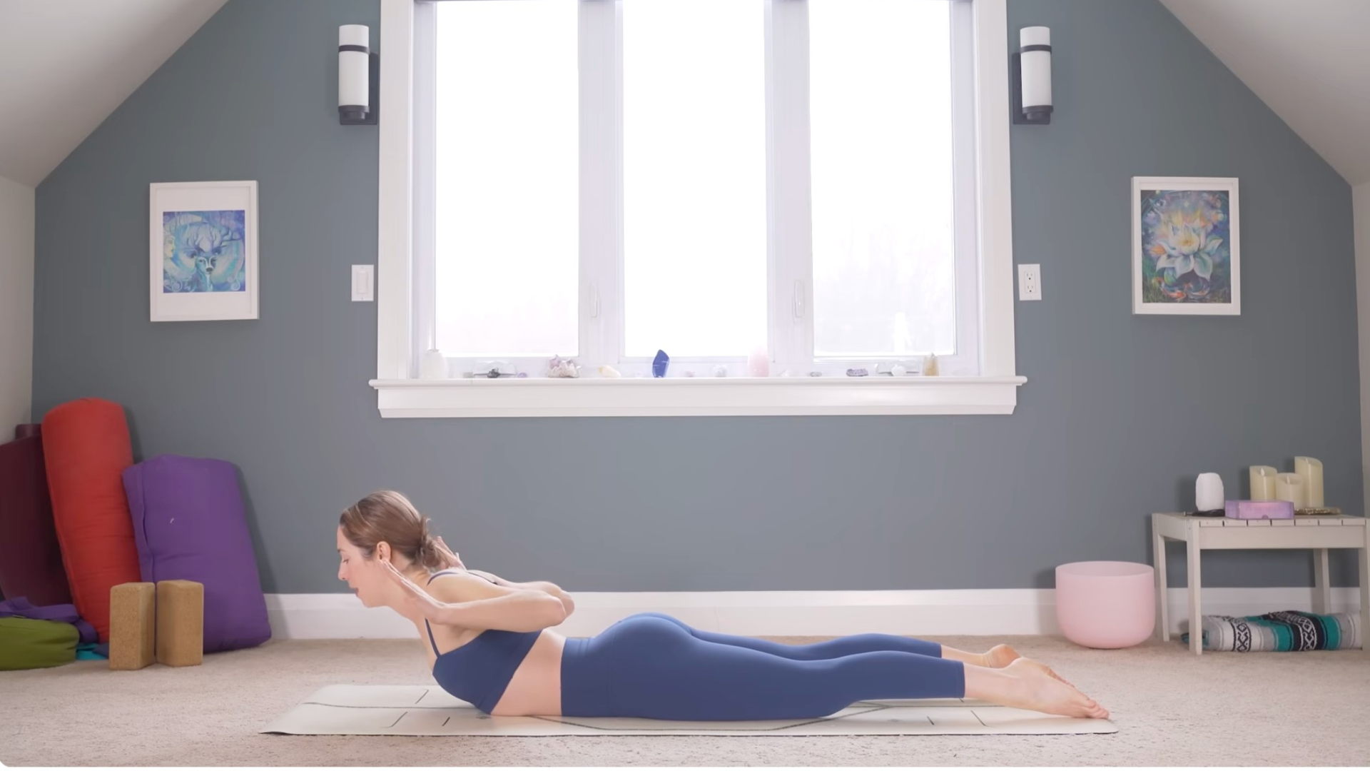 Woman lying on her mat with her palms at her sides and the tops of her feet pressing into the mat