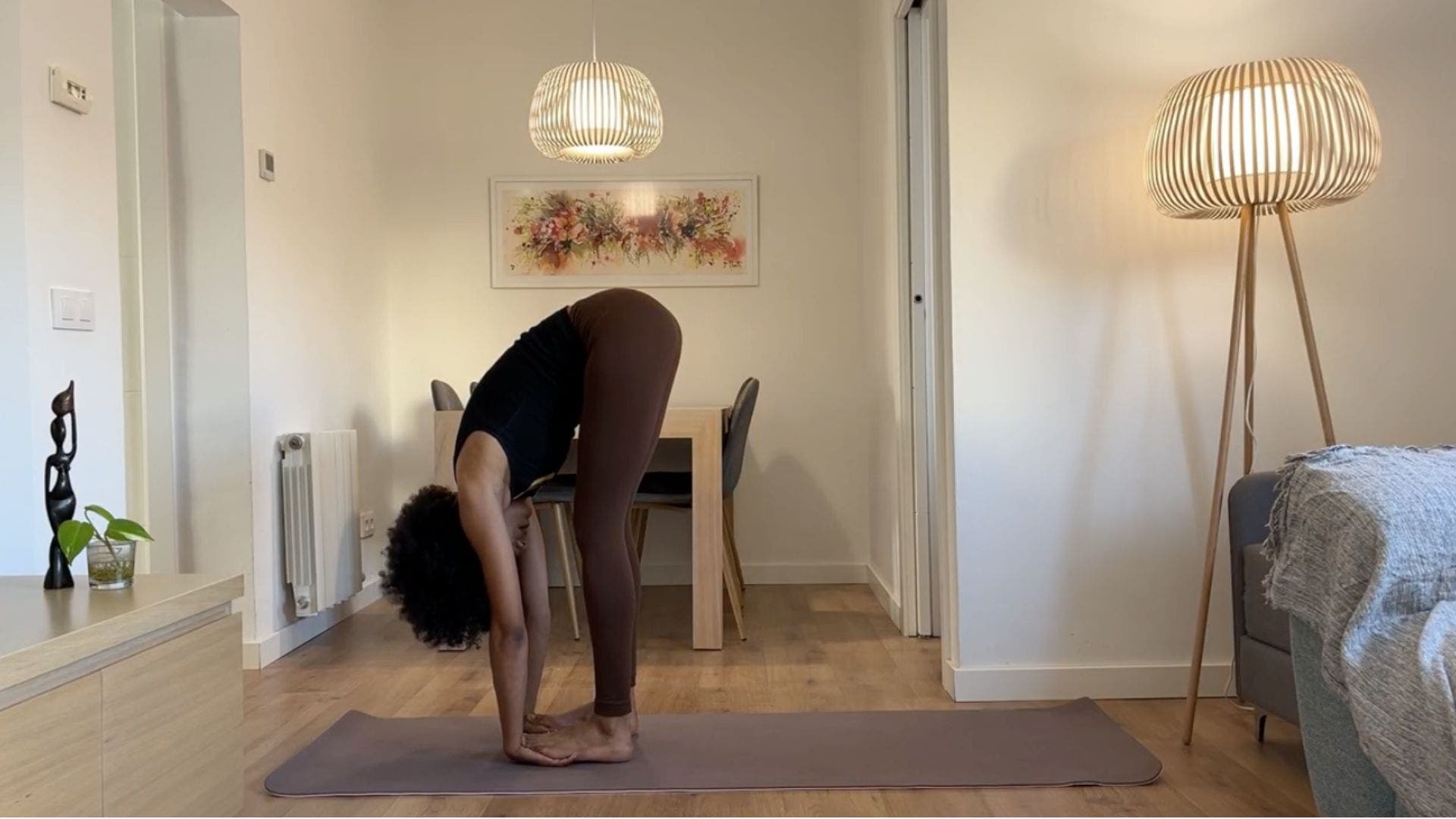 Yoga teacher practicing Standing Forward Bend.