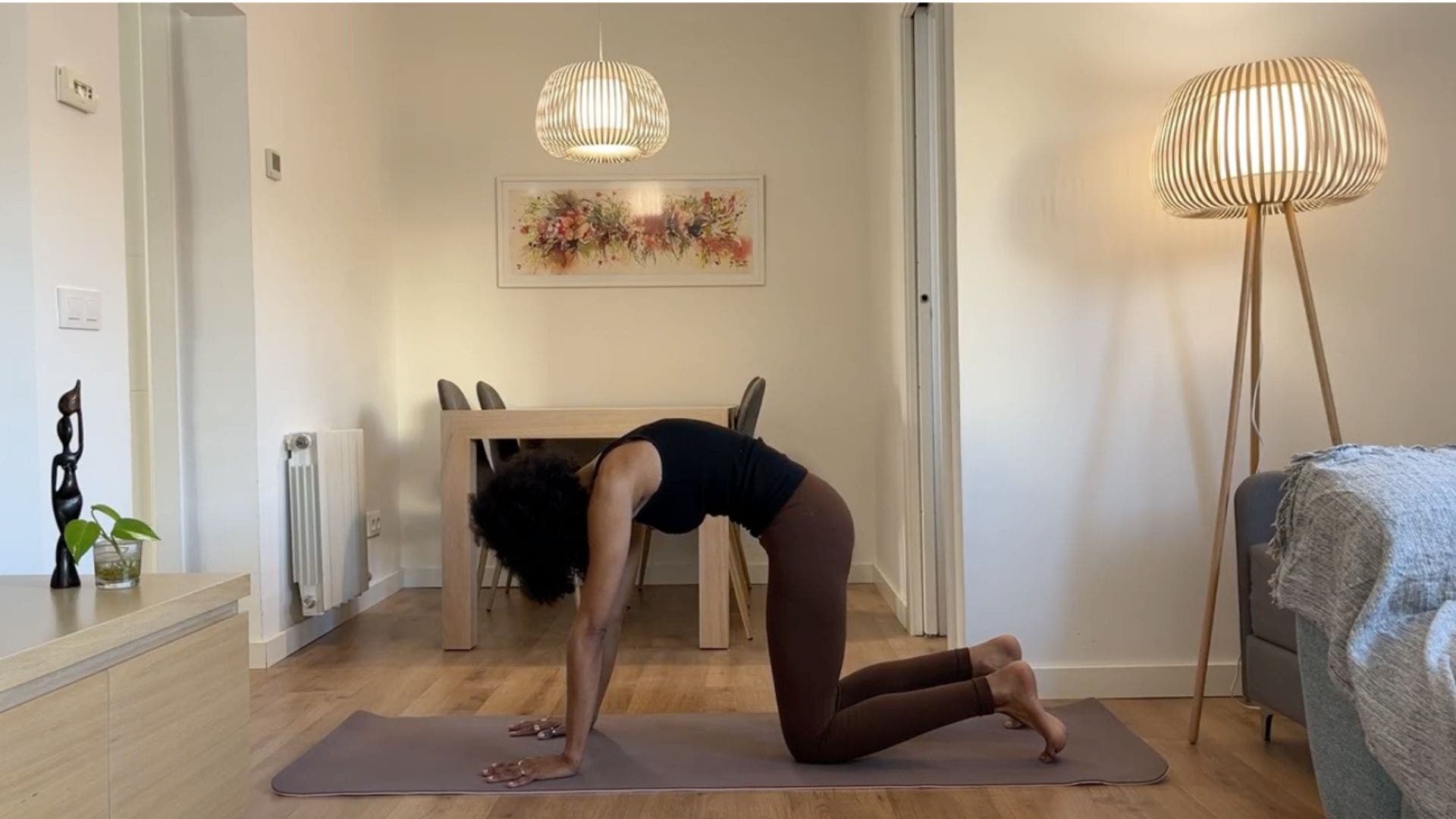 Yoga teacher practicing Cat Pose.