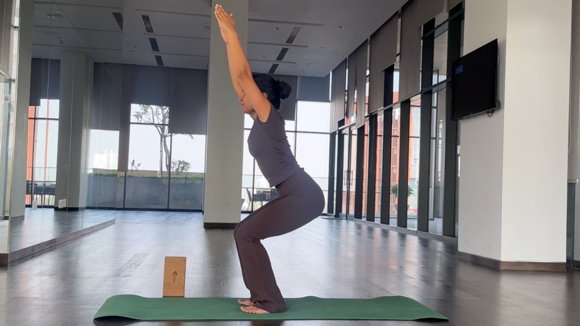Yoga instructor practicing Chair Pose.