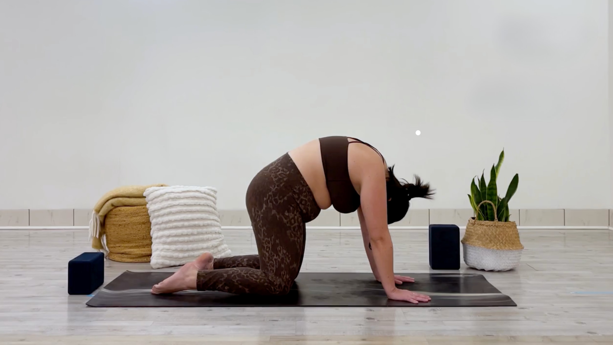 Yoga teacher Taylor Lorenz in Cat Pose, part of her self-love yoga practice