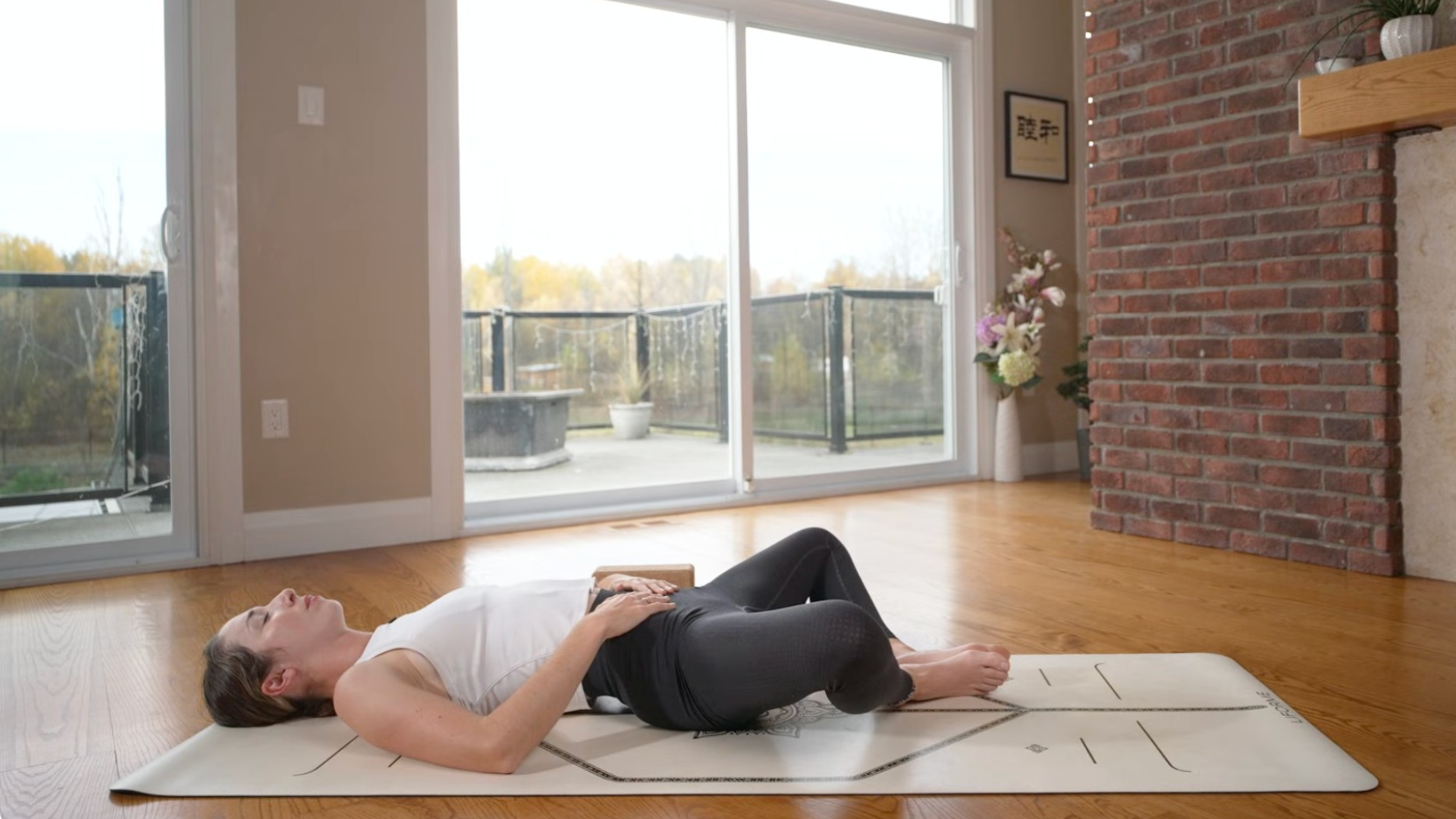 Woman lying on a mat practicing a yin yoga sequence including a hip opener