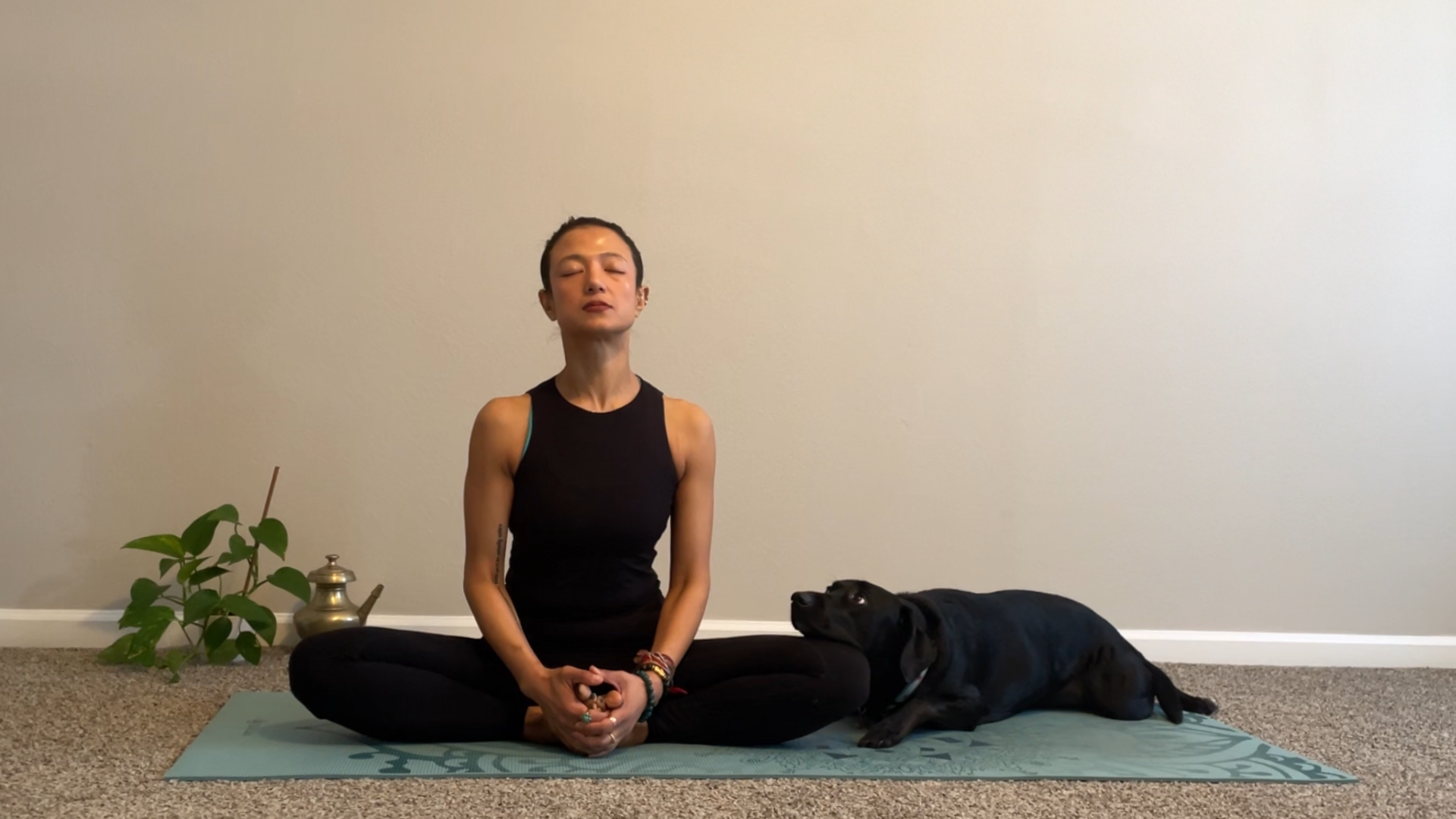 Woman sitting on a yoga mat with the bottoms of her feet together