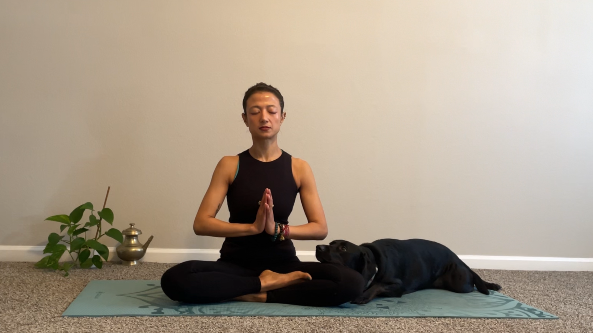 Woman sitting on a yoga mat in Lotus Pose during a yoga for anger practice