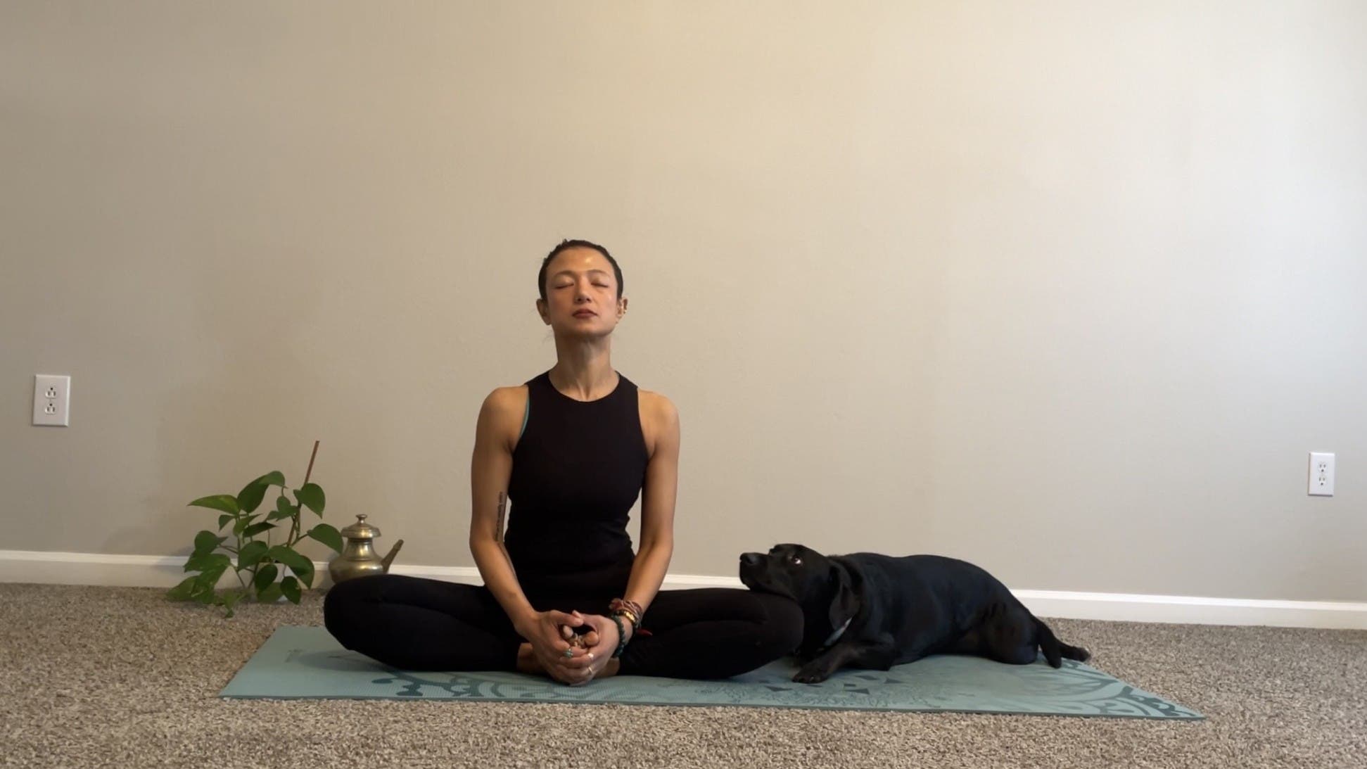 Woman sitting on a mat practicing yoga for anxiety 
