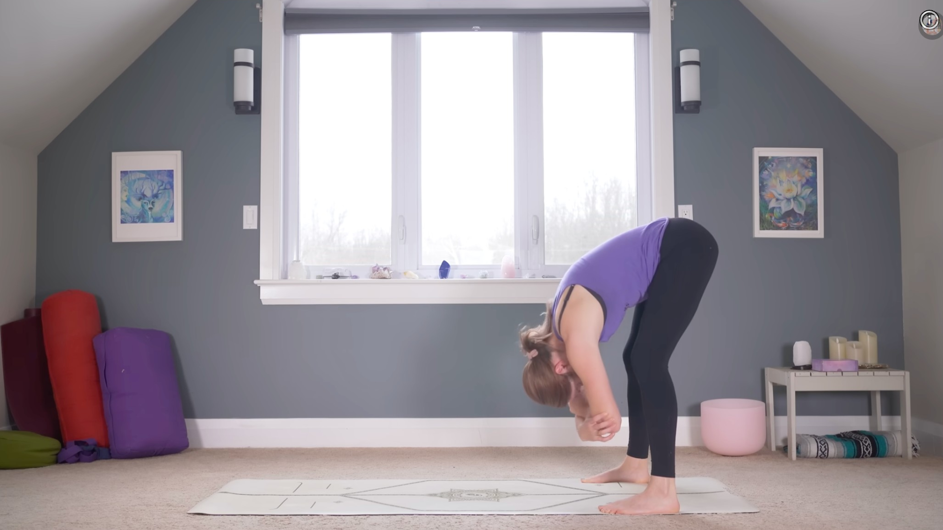 Woman on a yoga mat leaning forward and holding opposite elbows