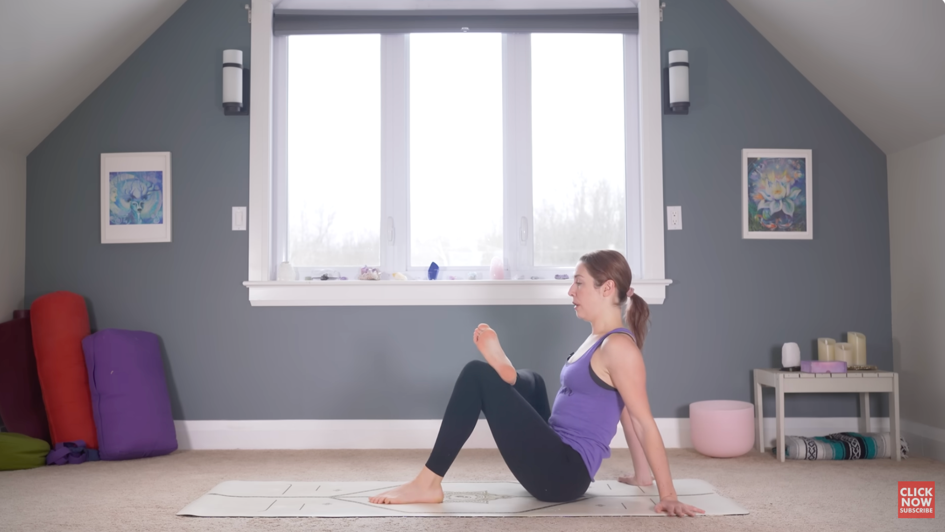 Woman sitting on a mat with one ankle crossed over the opposite knee
