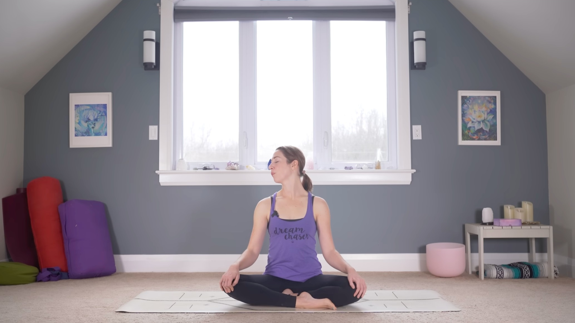 Woman sitting cross-legged on a yoga mat practicing neck stretches