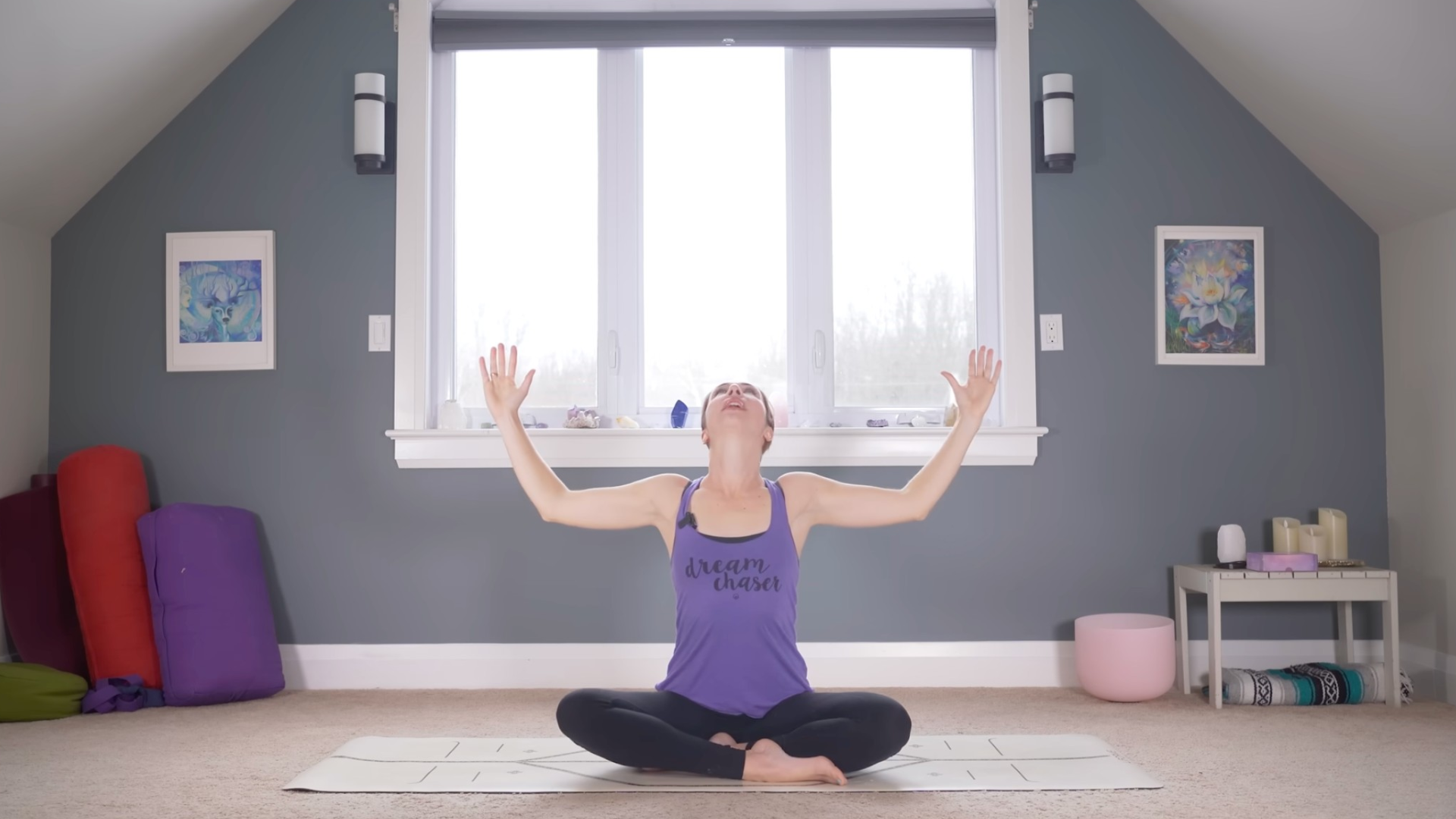 Woman sitting cross-legged with her arms reaching to the sides