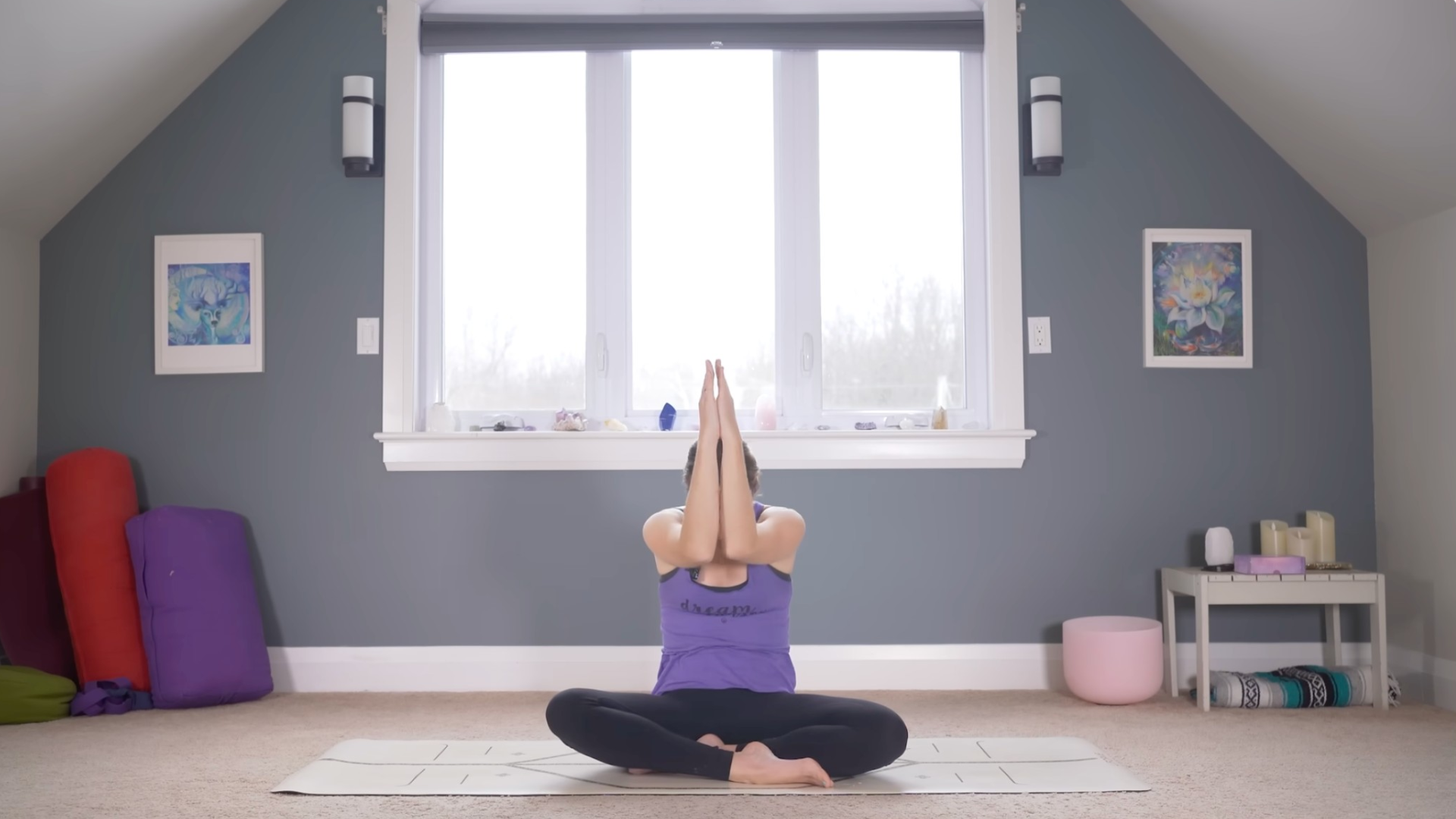 Woman sitting crosslegged with her forearms touching in front of her