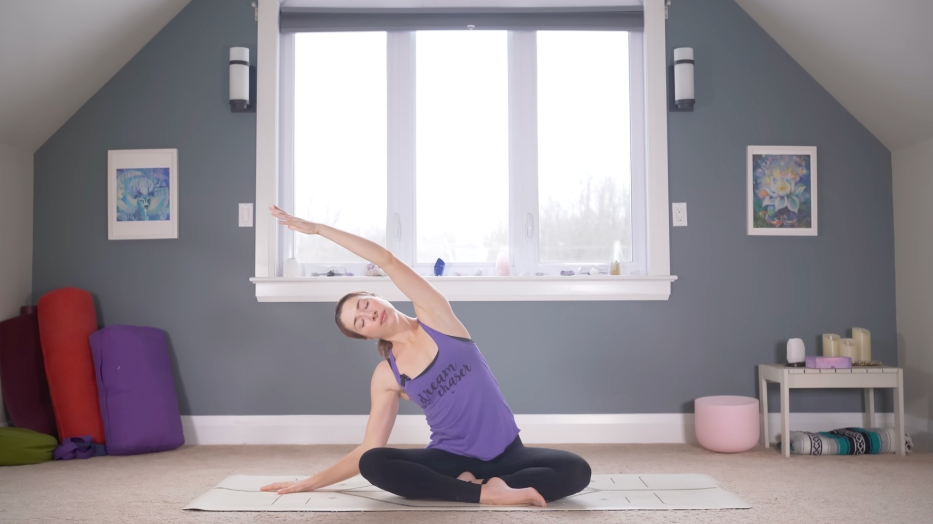 Woman sitting cross-legged on a mat and leaning to one side