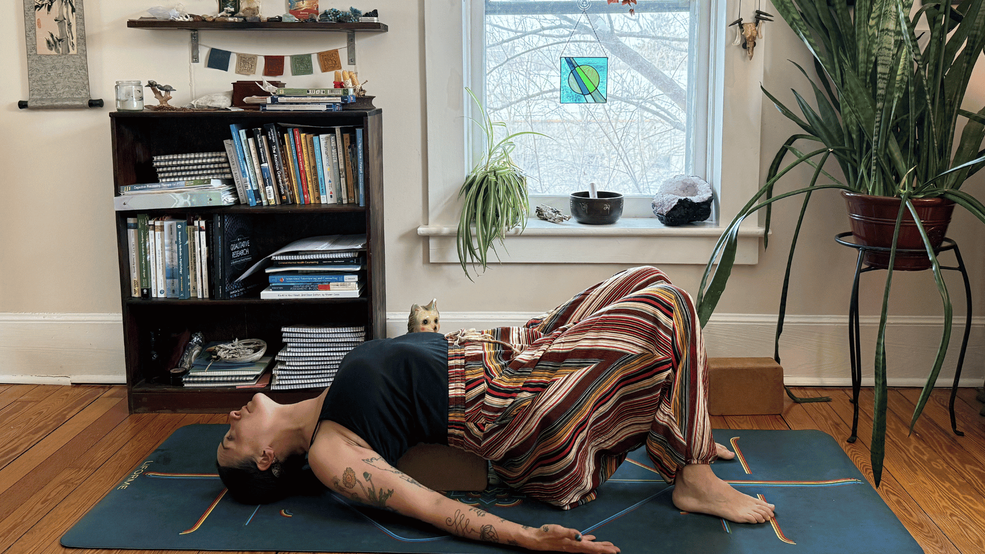 Woman lying on a mat in Supported Bridge Pose during a yoga for courage exercise