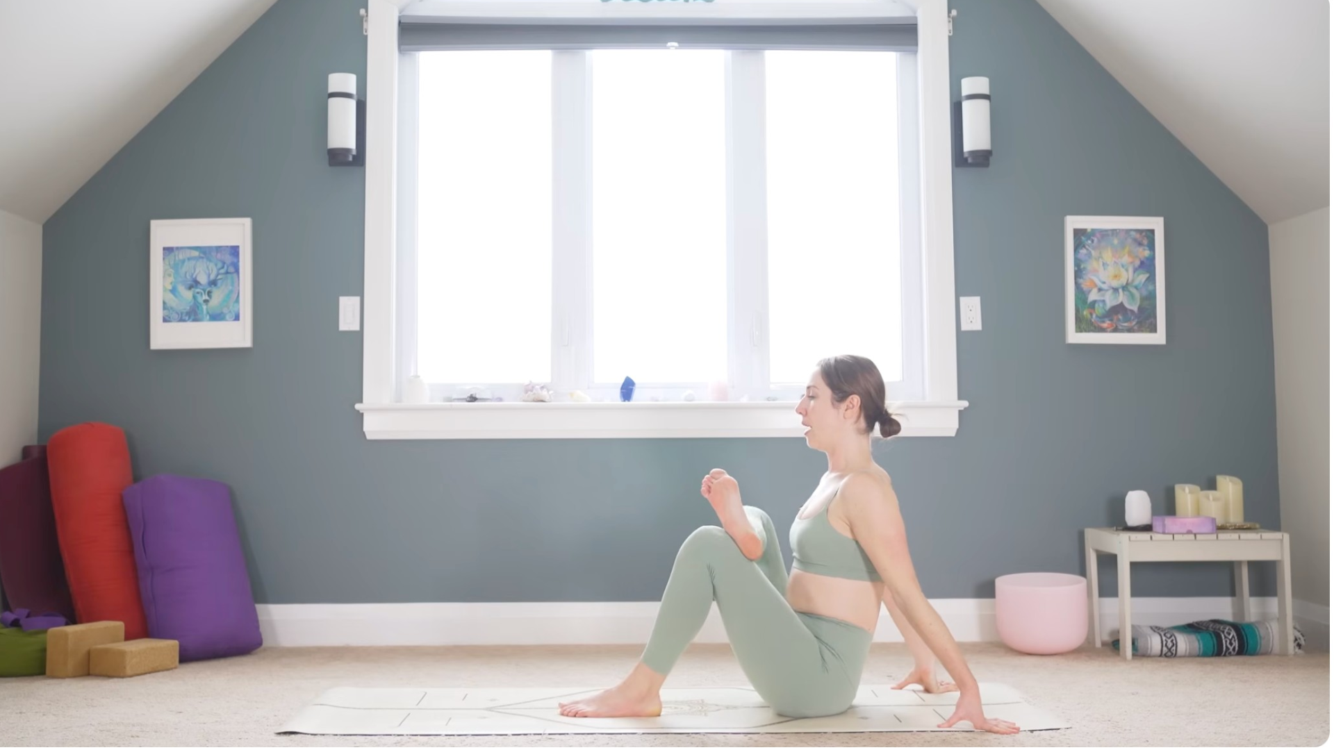 Woman sitting on a mat with her legs in a figure-4 stretch similar to Pigeon Pose during a 10-minute morning yoga routine