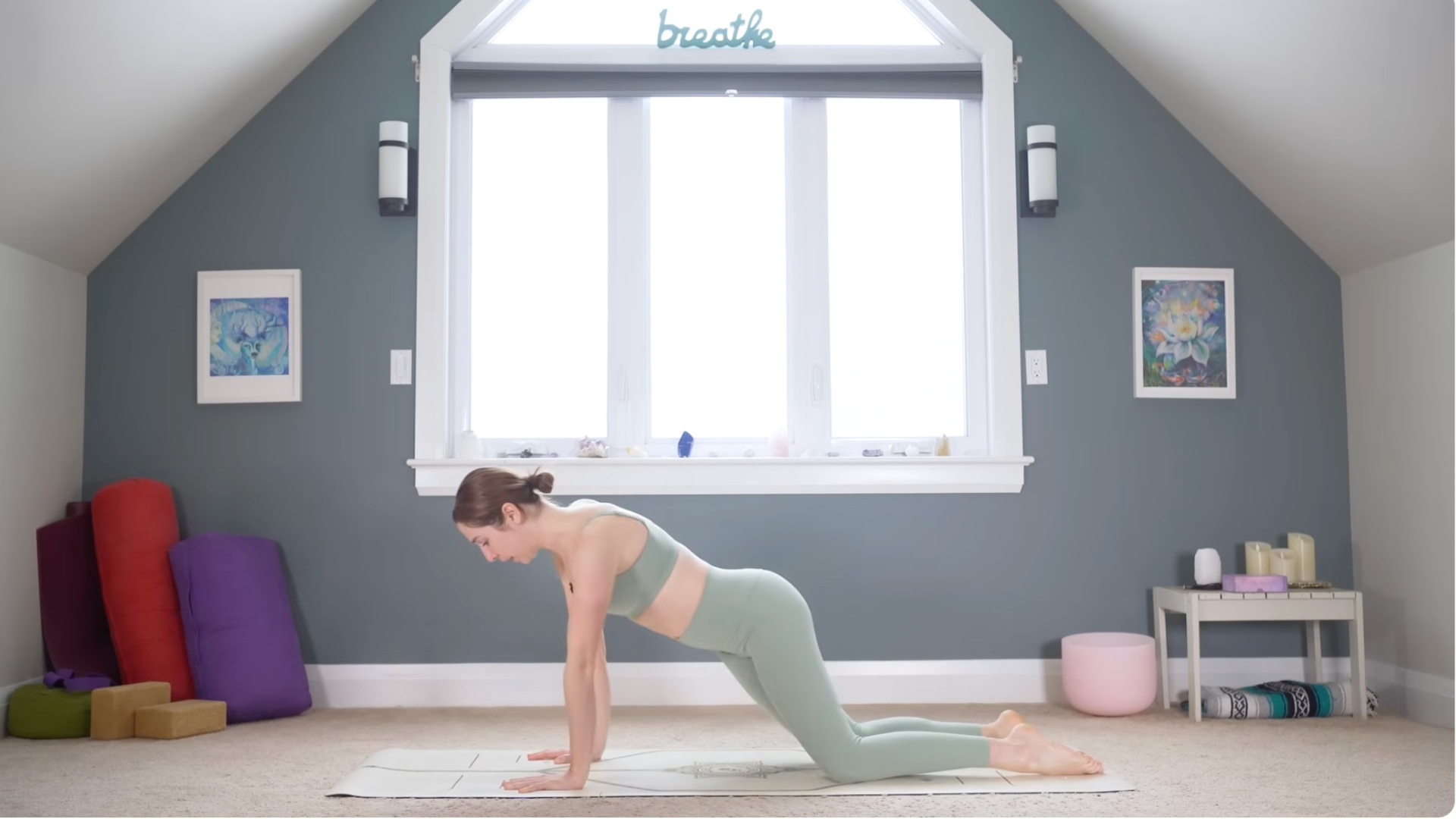 Woman with her hands and knees on the yoga mat while making hip circles