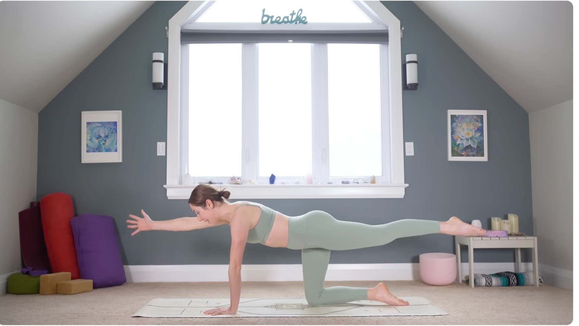 Woman in a variation of Bird Dog on her mat