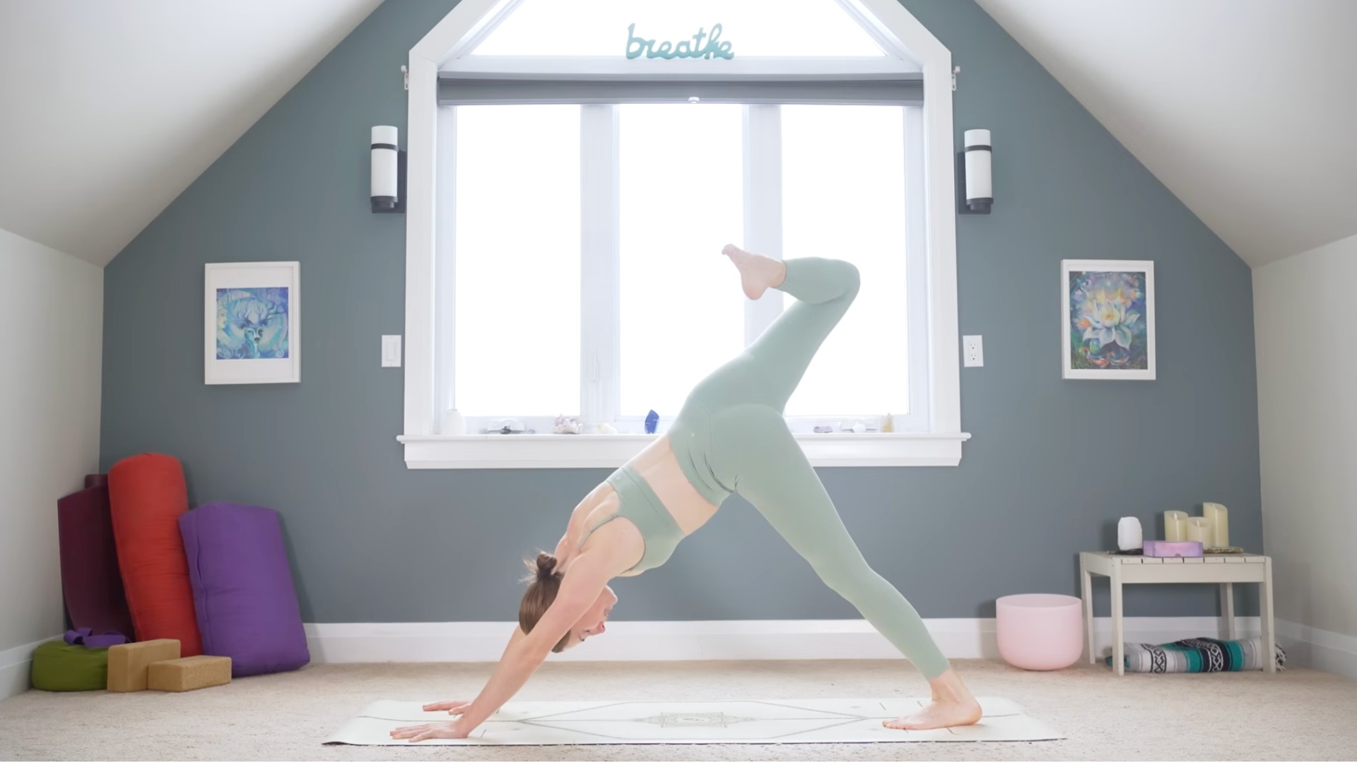 Woman with her right leg lifted and her knee bent in Scorpion Dog or Three-Legged Dog