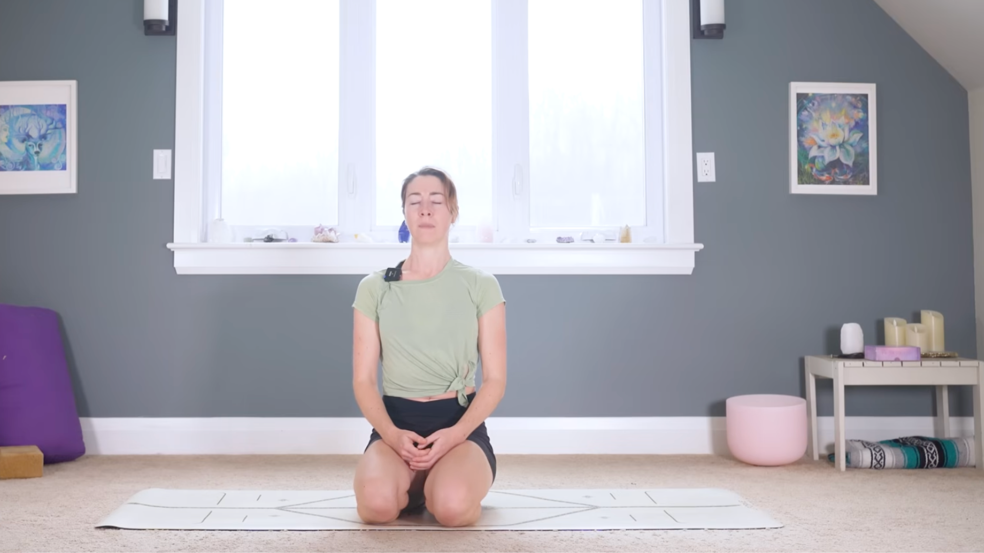 Woman kneeling on a mat and sitting back on her heels after a 10-minute morning yoga for back pain practice