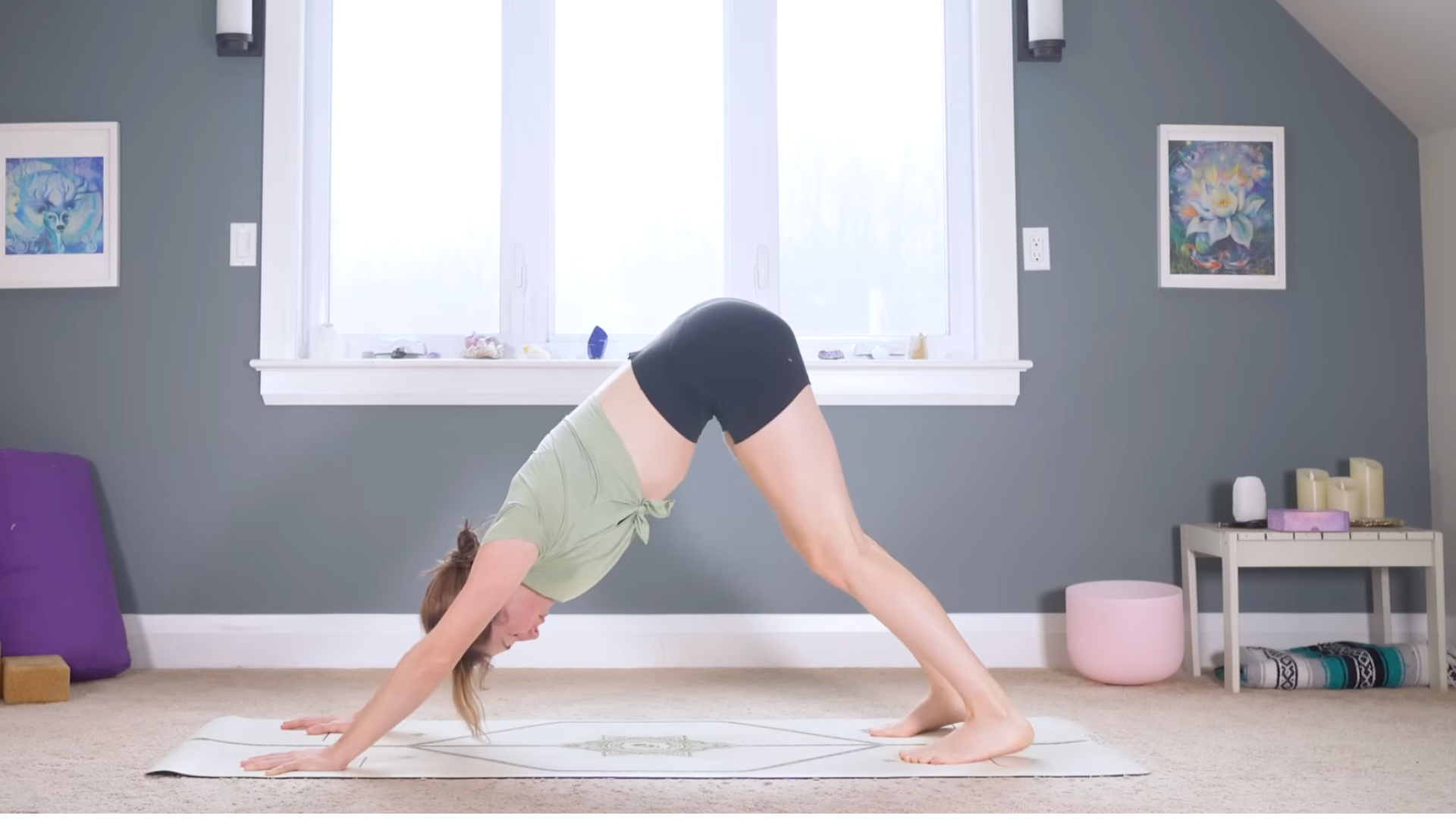 Woman standing on a mat in Downward-Facing Dog Pose