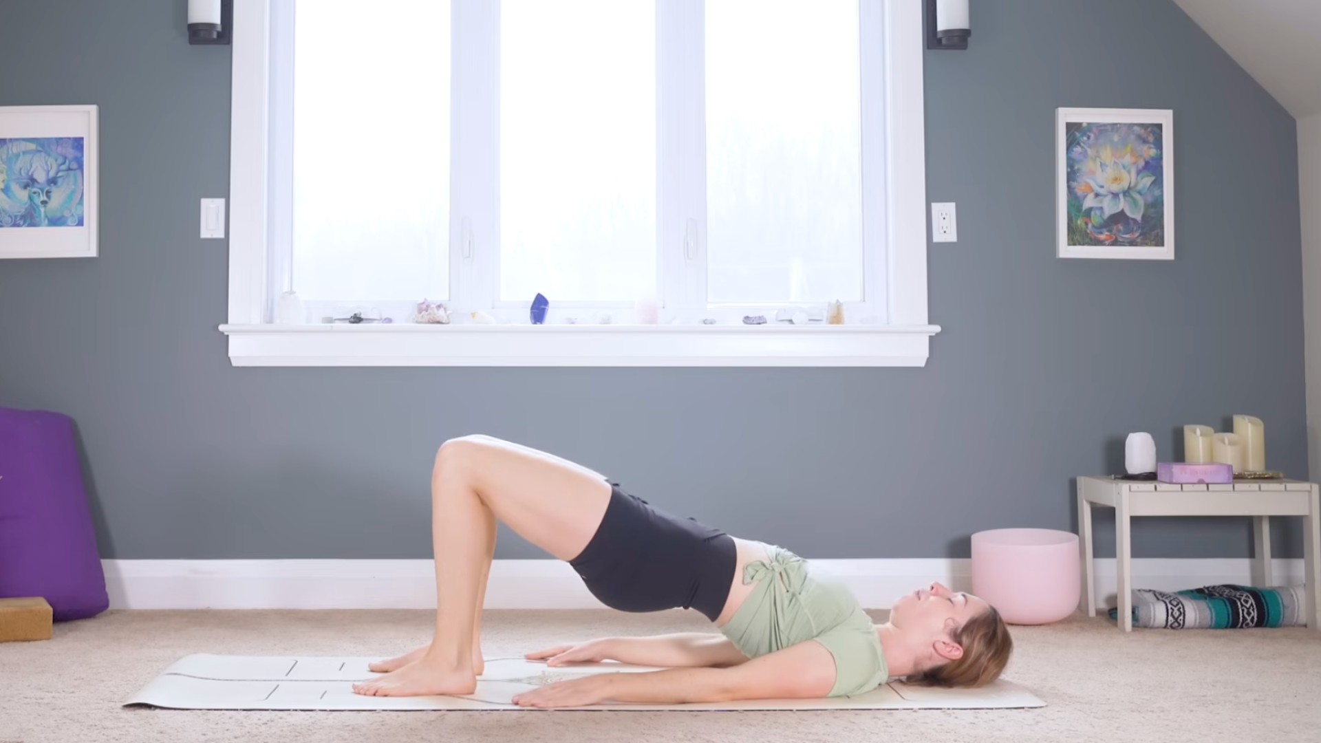 Woman on a mat lying on her back and lifting her hips in a yoga for back exercise