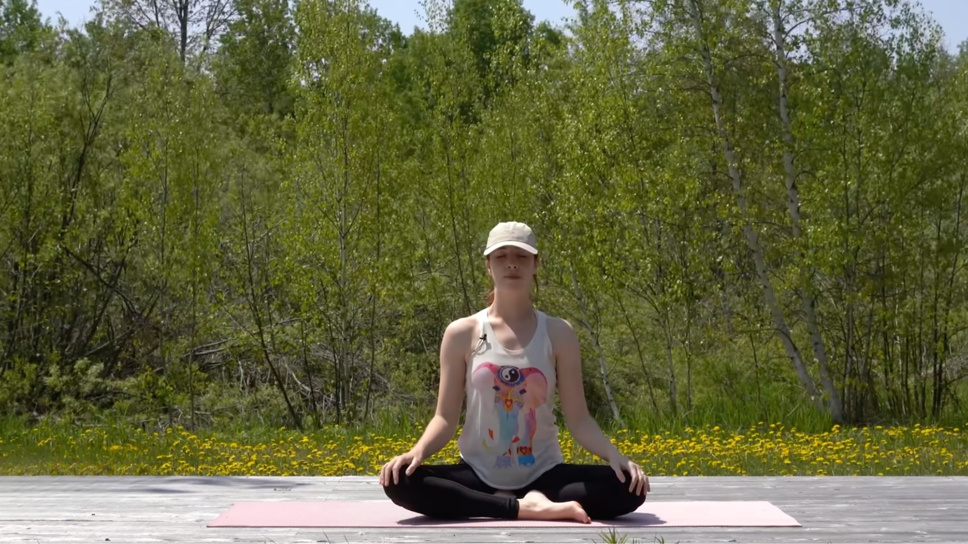 Woman sitting on a yoga mat pausing in meditation after a 10-minute morning yoga routine