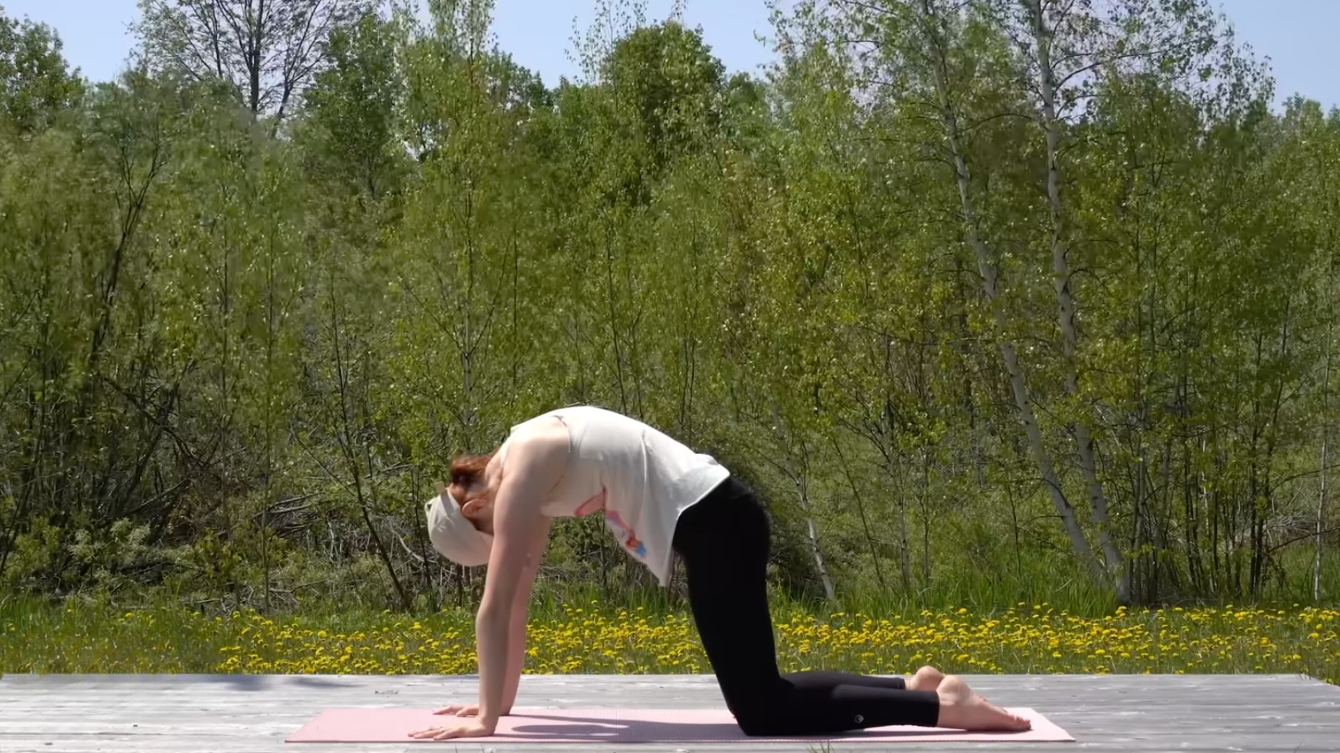 Woman kneeling on a mat rounding her back