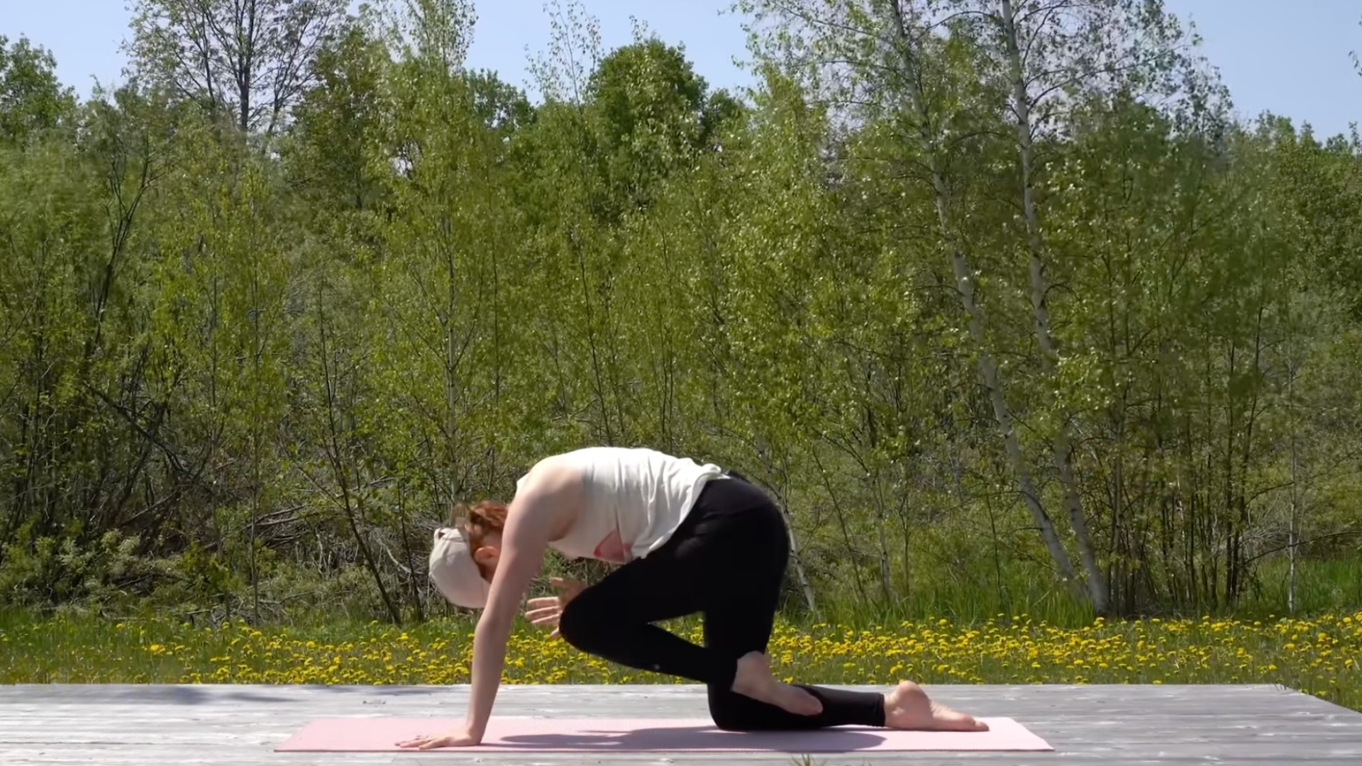 Woman kneeling on a mat with her knee coming toward her elbow
