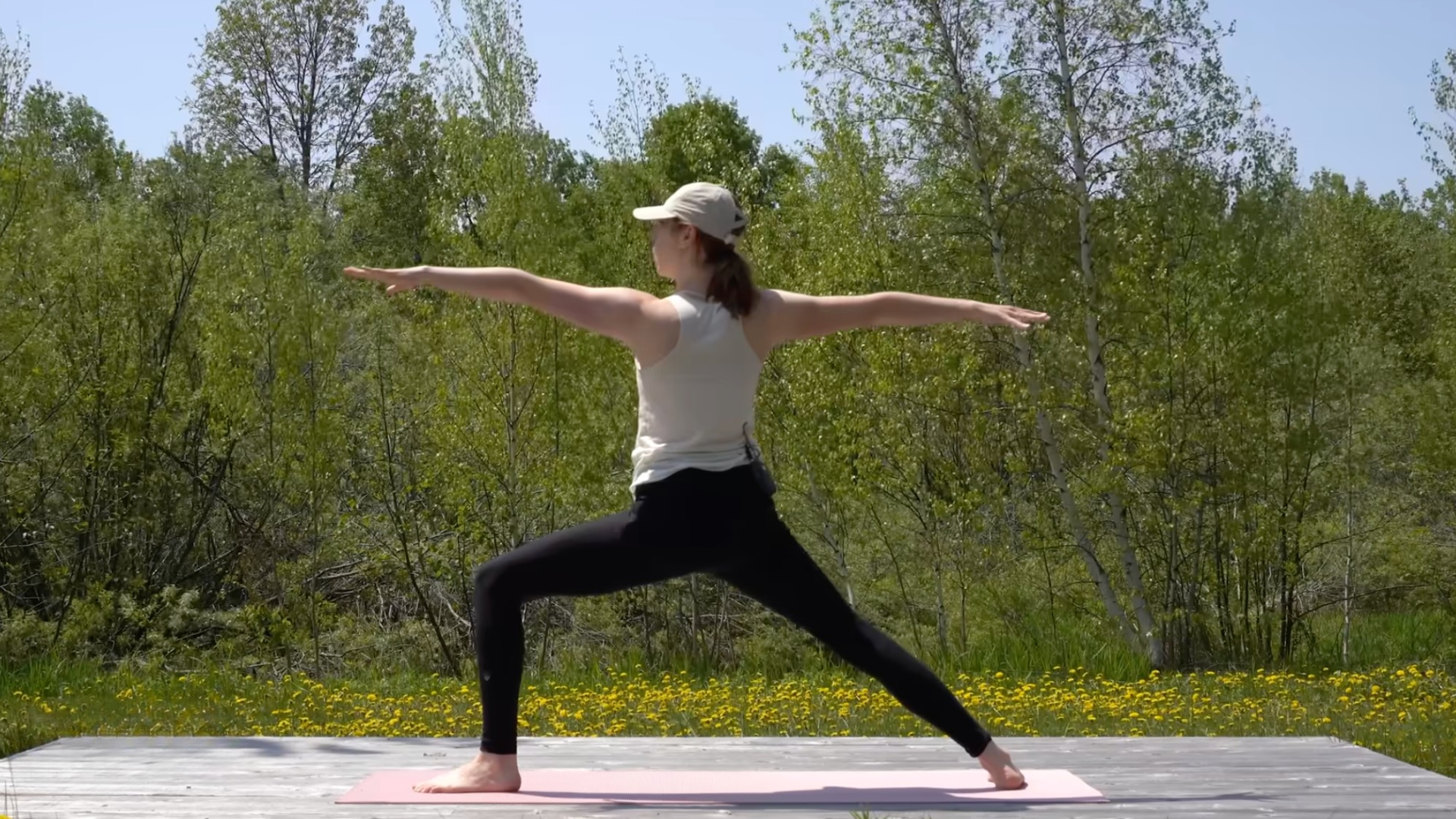 Woman standing on a mat in Warrior 2