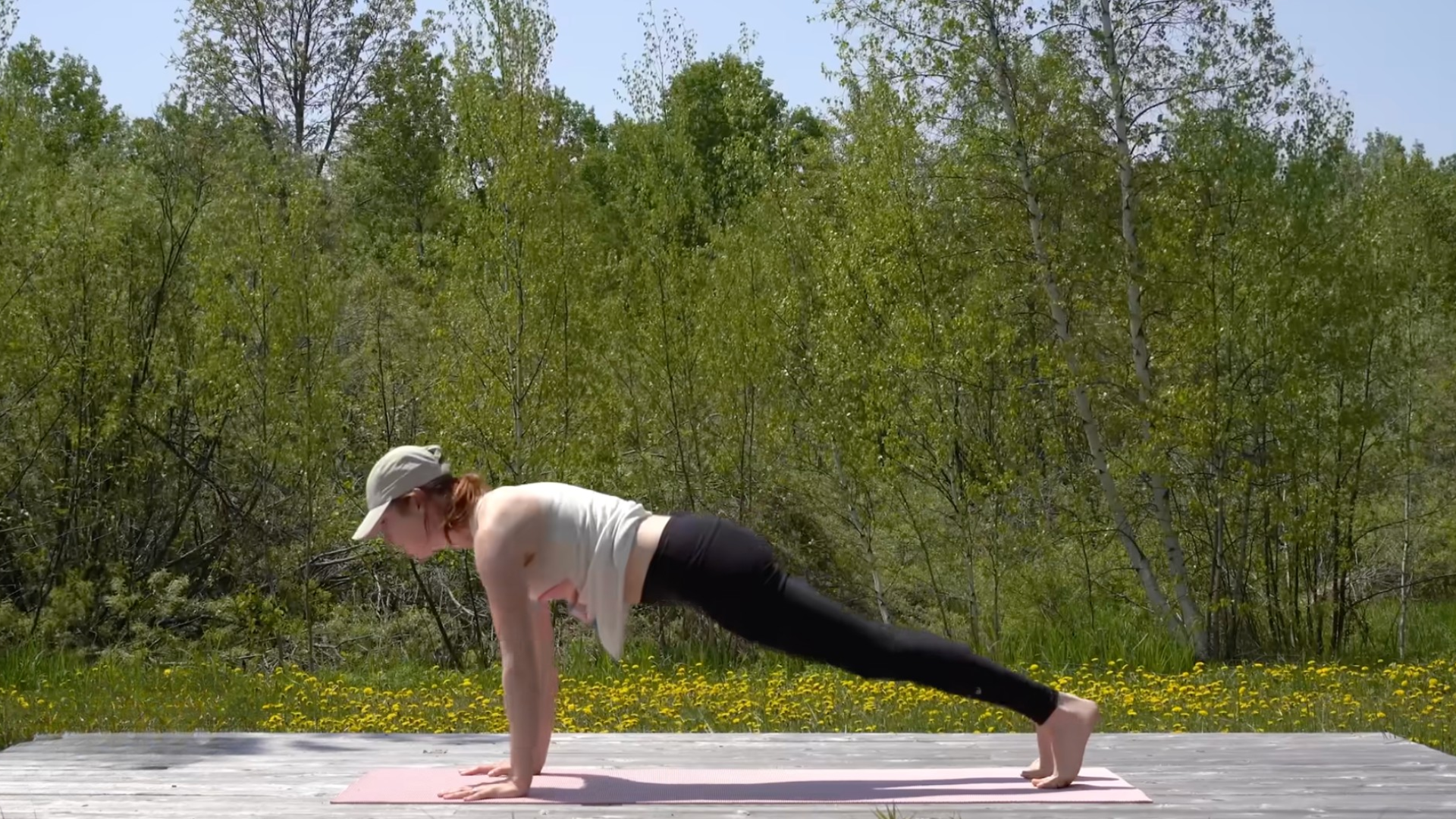 Woman hovering over a yoga mat in Plank Pose