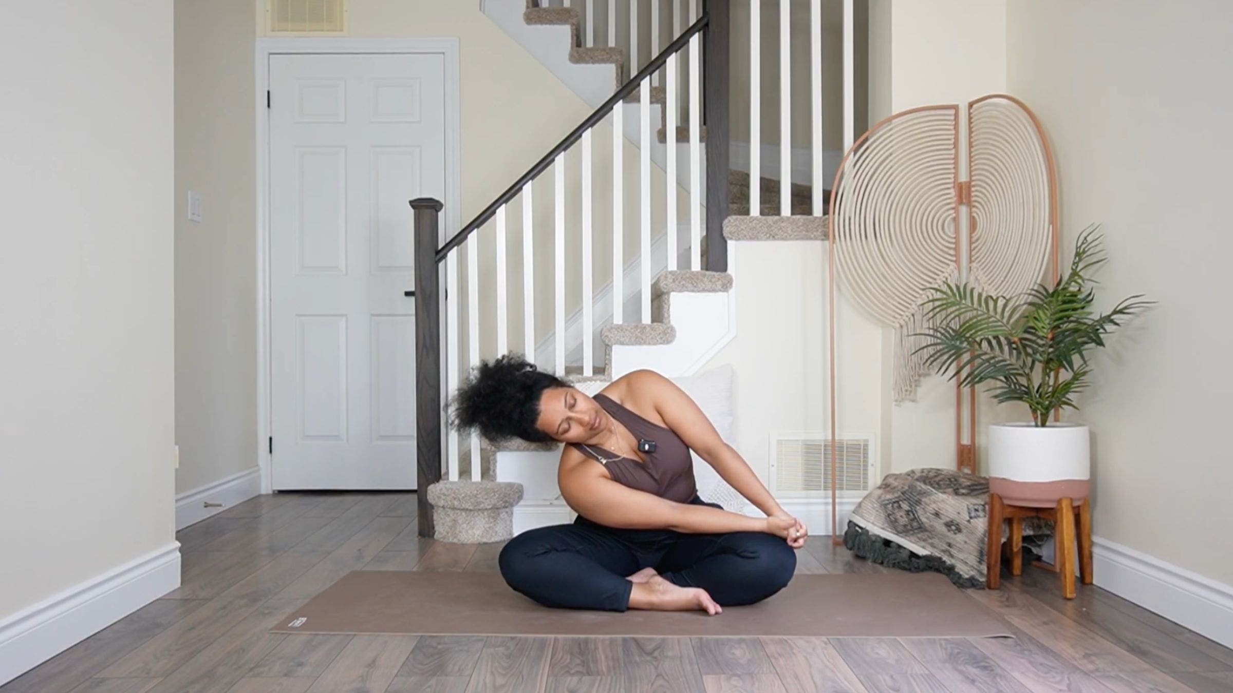 Yoga teacher practicing seated side stretch.