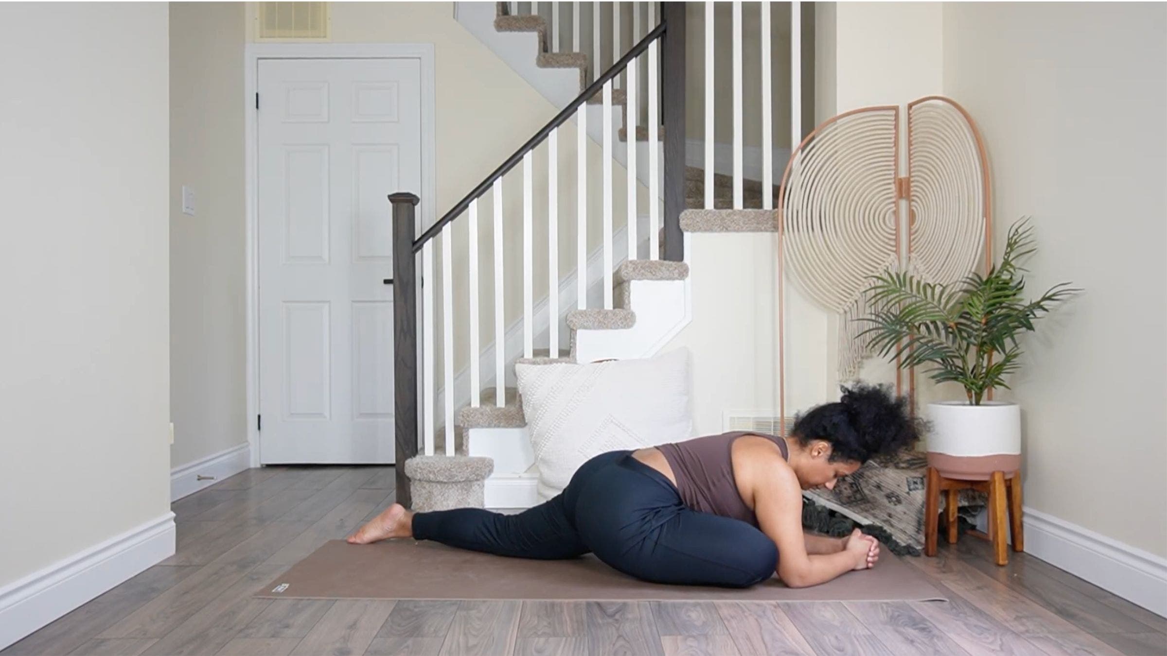 Yoga teacher practicing Pigeon Pose variation.