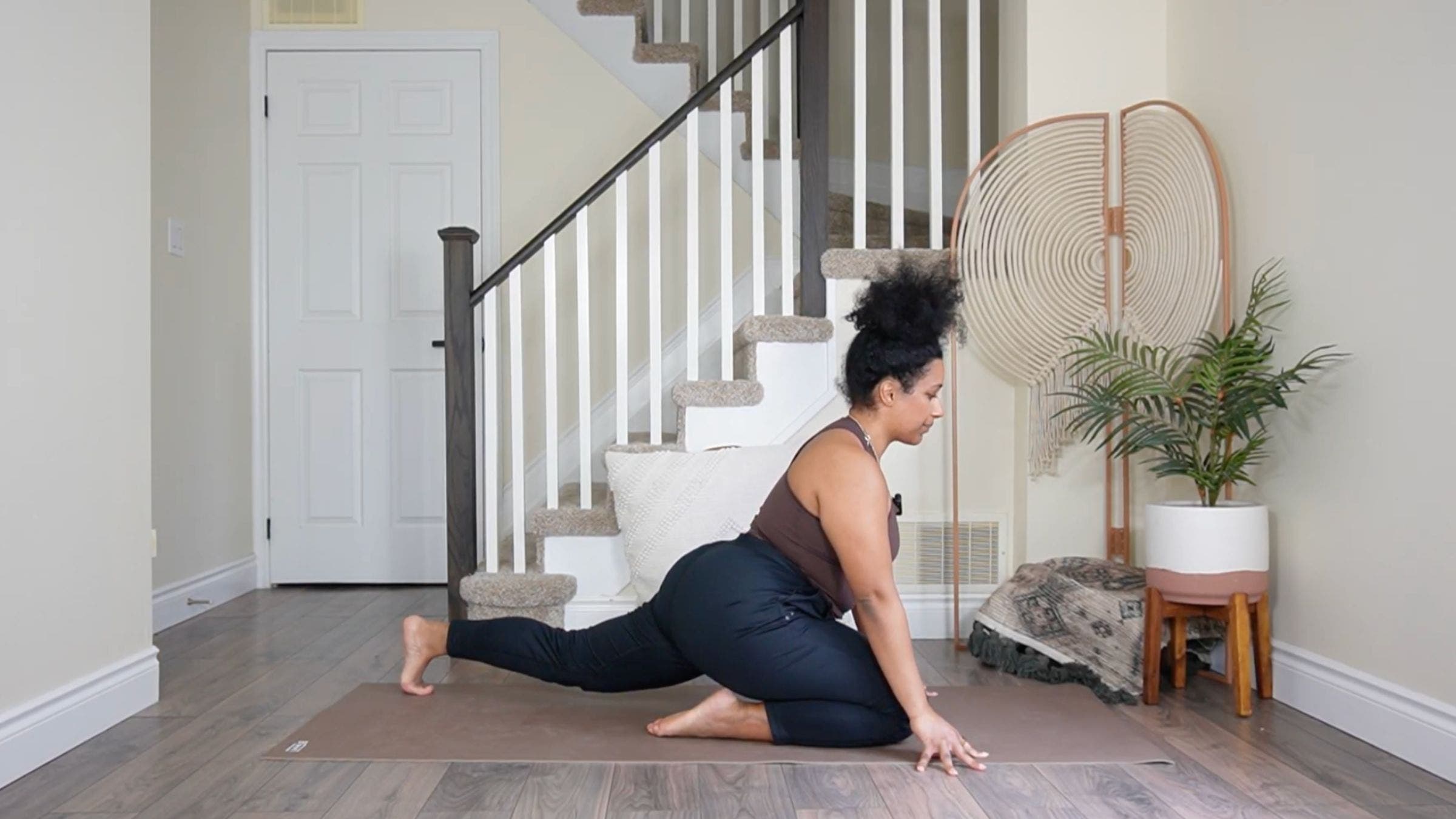 Yoga teacher practicing Pigeon Pose variation.
