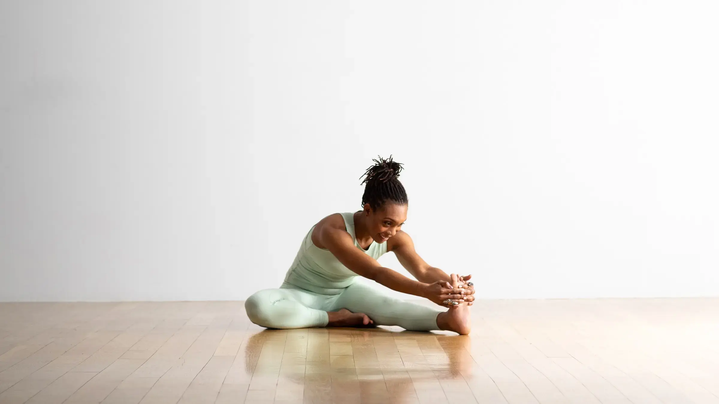 A woman in head-to-Knee Pose, one of the best yoga poses for back pain