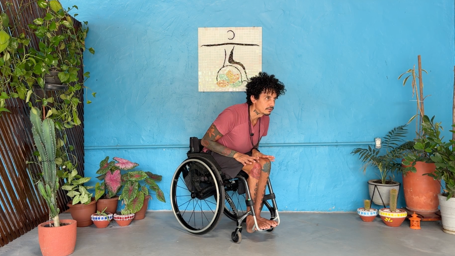 Man sitting in a wheelchair leaning forward in Chaturanga