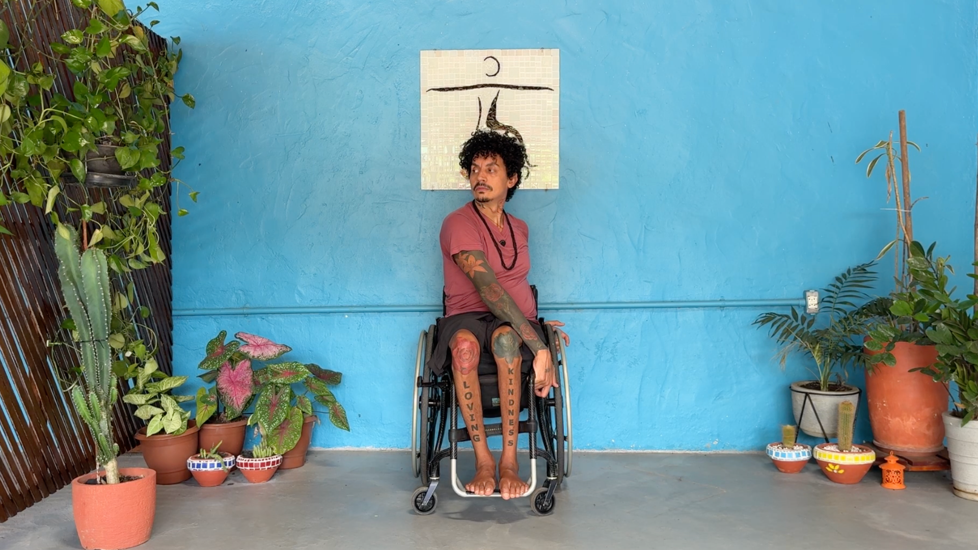 Yoga teacher sitting in a wheelchair twisting toward the left