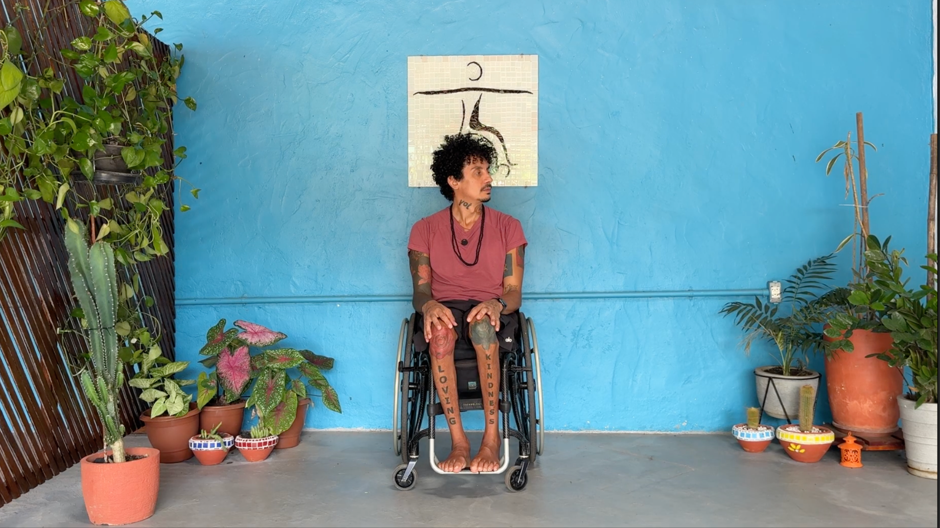 Yoga teacher sitting in a wheelchair stretching his head to one side