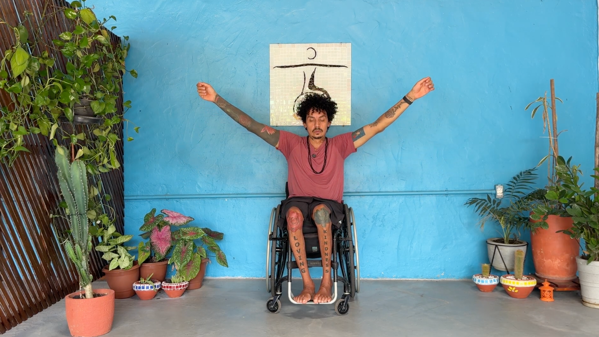 Yoga teacher sitting in a wheelchair making arm circles