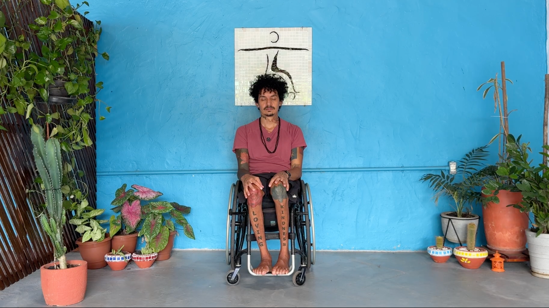 Yoga teacher in a wheelchair leading a class through a moment of centering