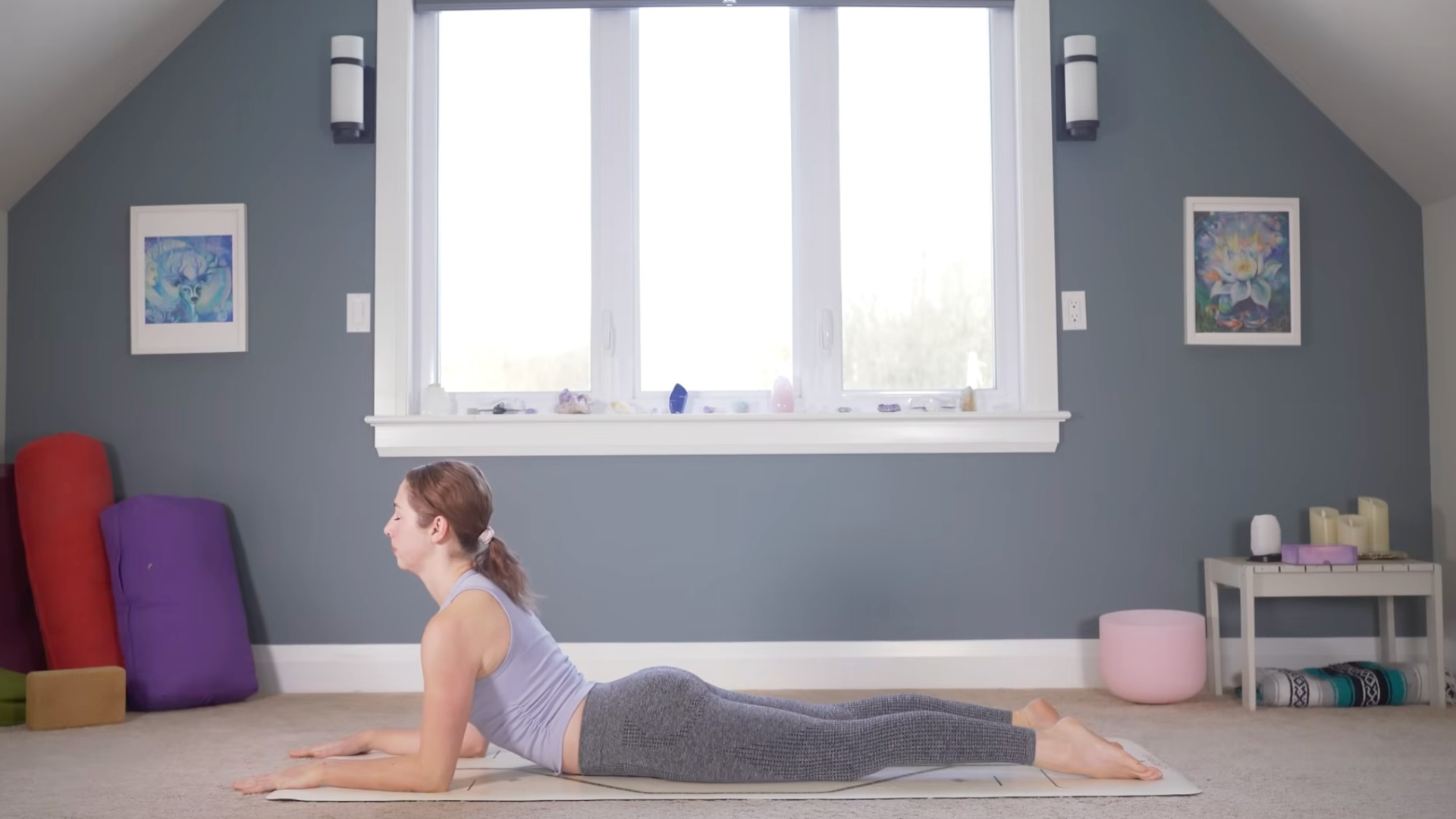 Woman lying on her belly on a mat in Sphinx Pose