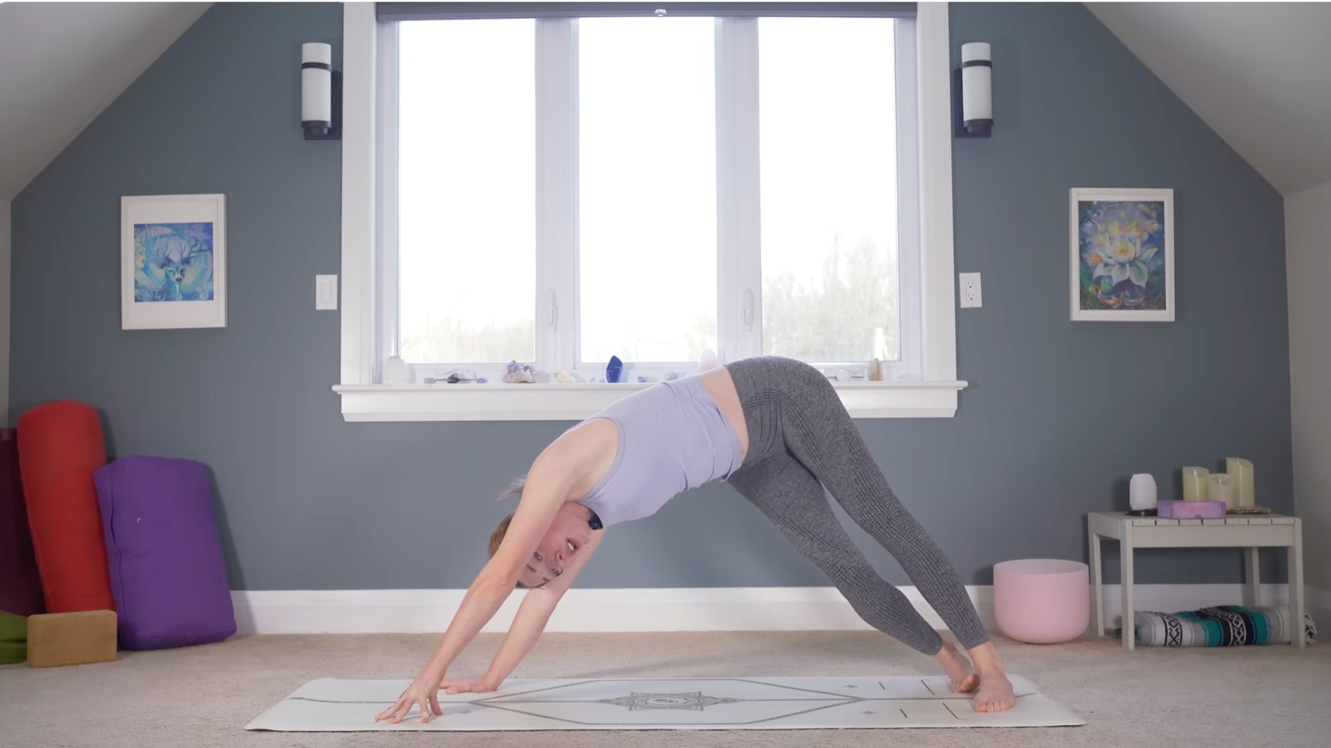 Woman in Downward-Facing Dog leaning to one side in a version of Side Plank