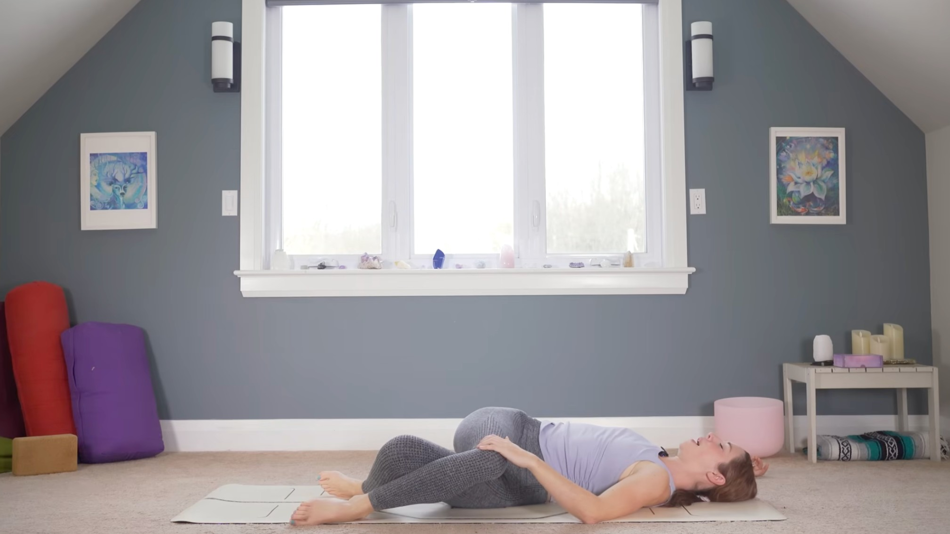 Woman lying on her back reclining with her right thigh crossed over her left in a slow yoga for flexibility class