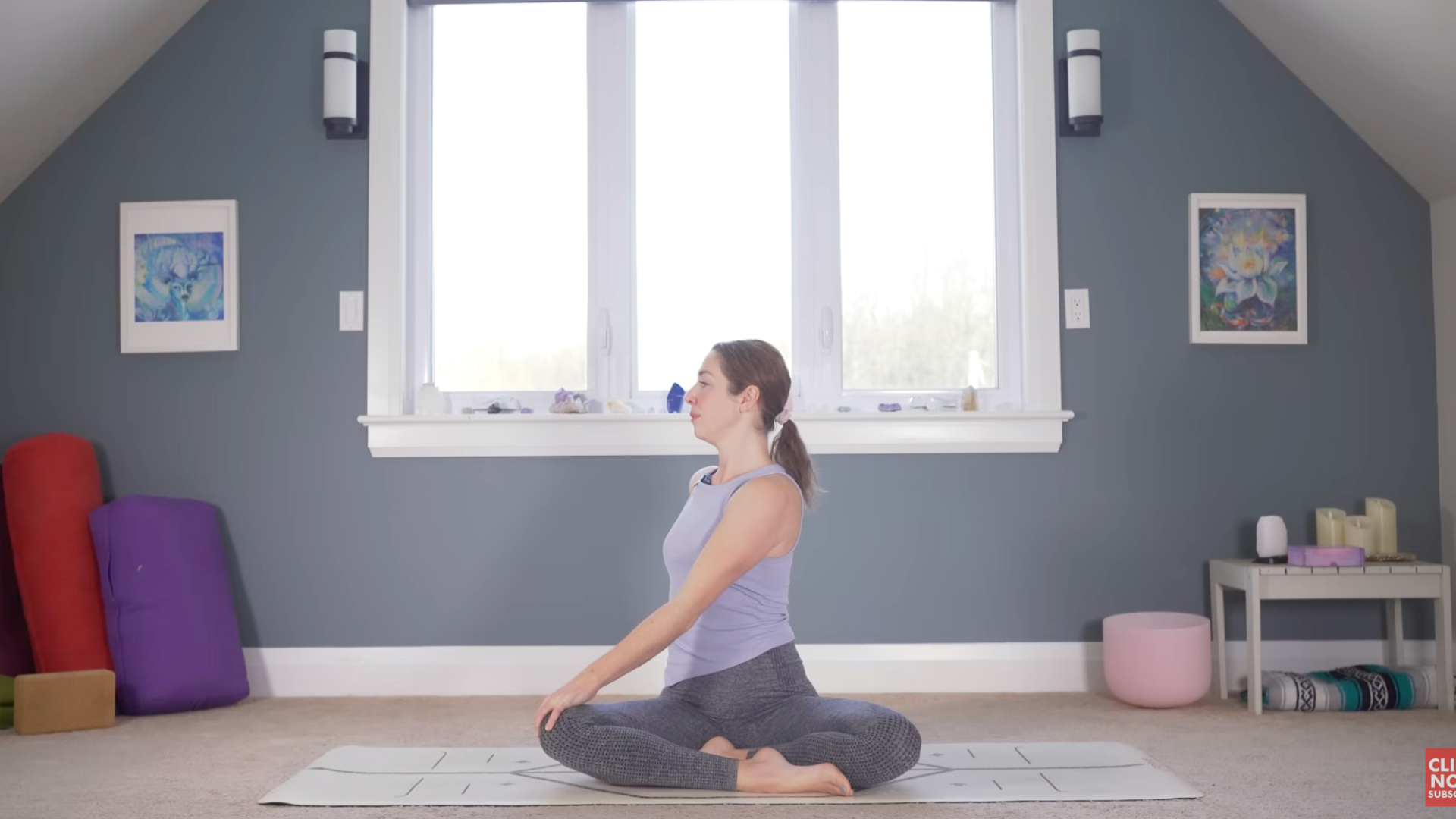 Woman sitting on a mat twisting toward her right