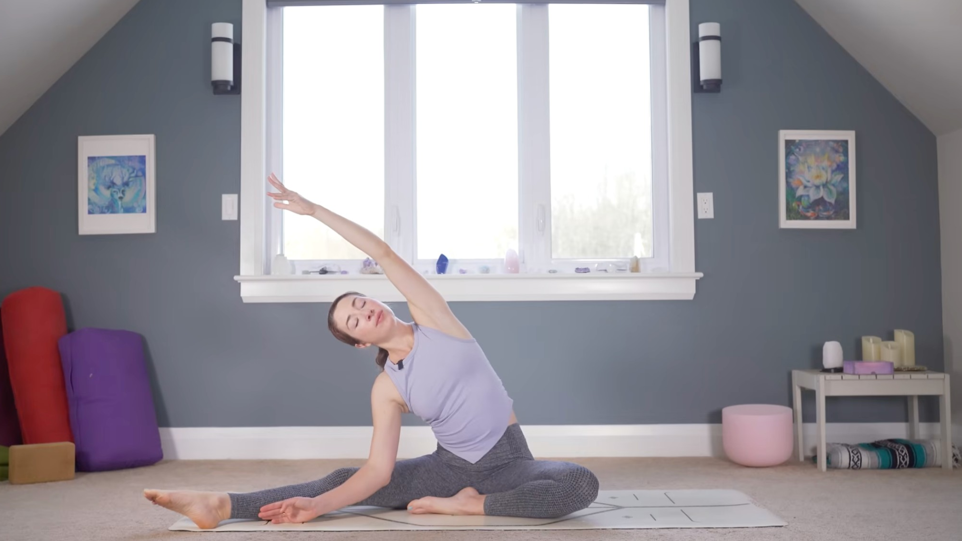 Woman sitting on a mat and leaning toward one side during a slow yoga for flexibility practice.