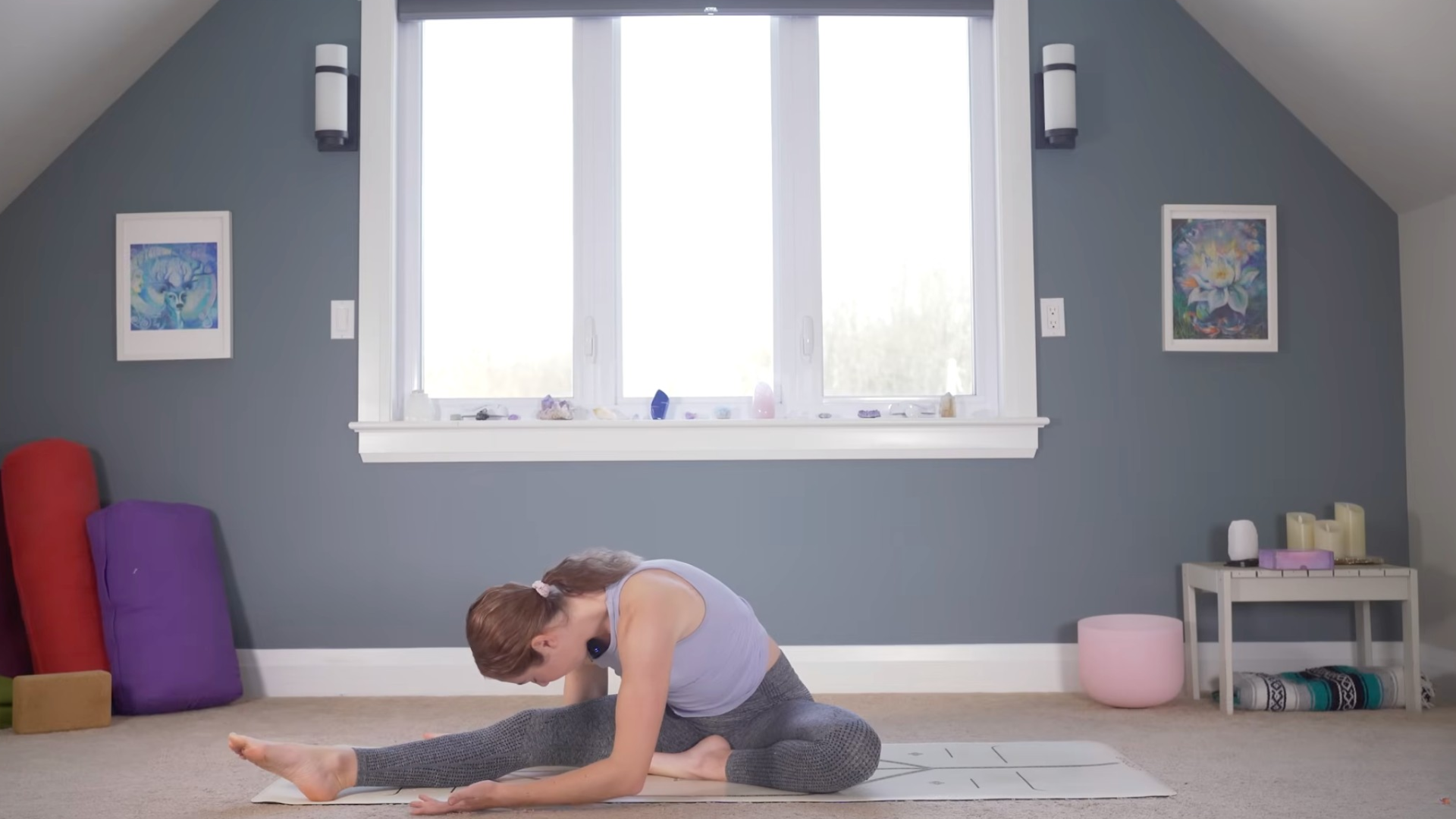 Woman sitting on a mat and leaning forward in a seated forward bend stretch
