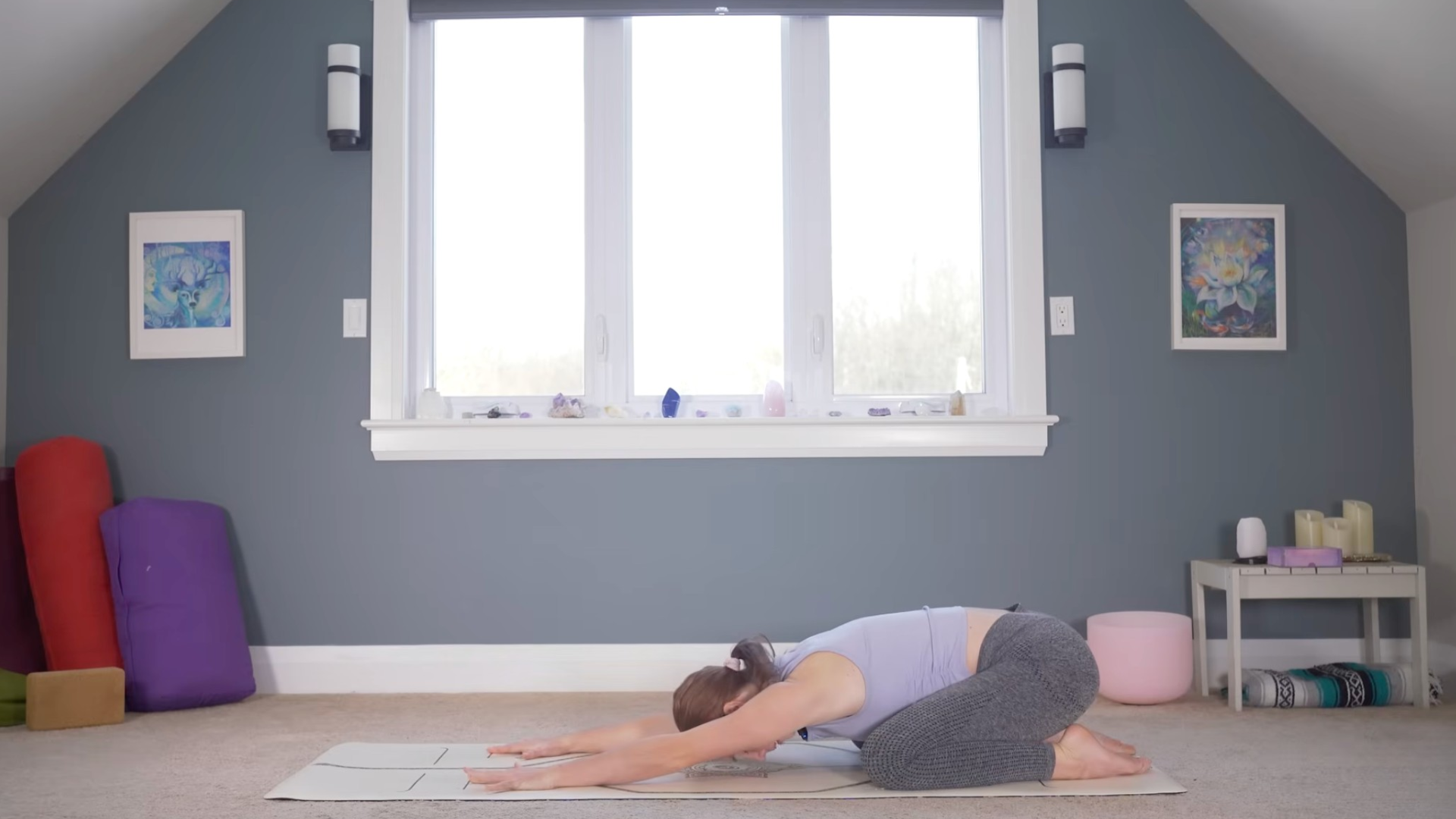 Woman kneeling on a yoga mat during a slow yoga for flexibility practice with her hips over her heels and her forehead on the mat