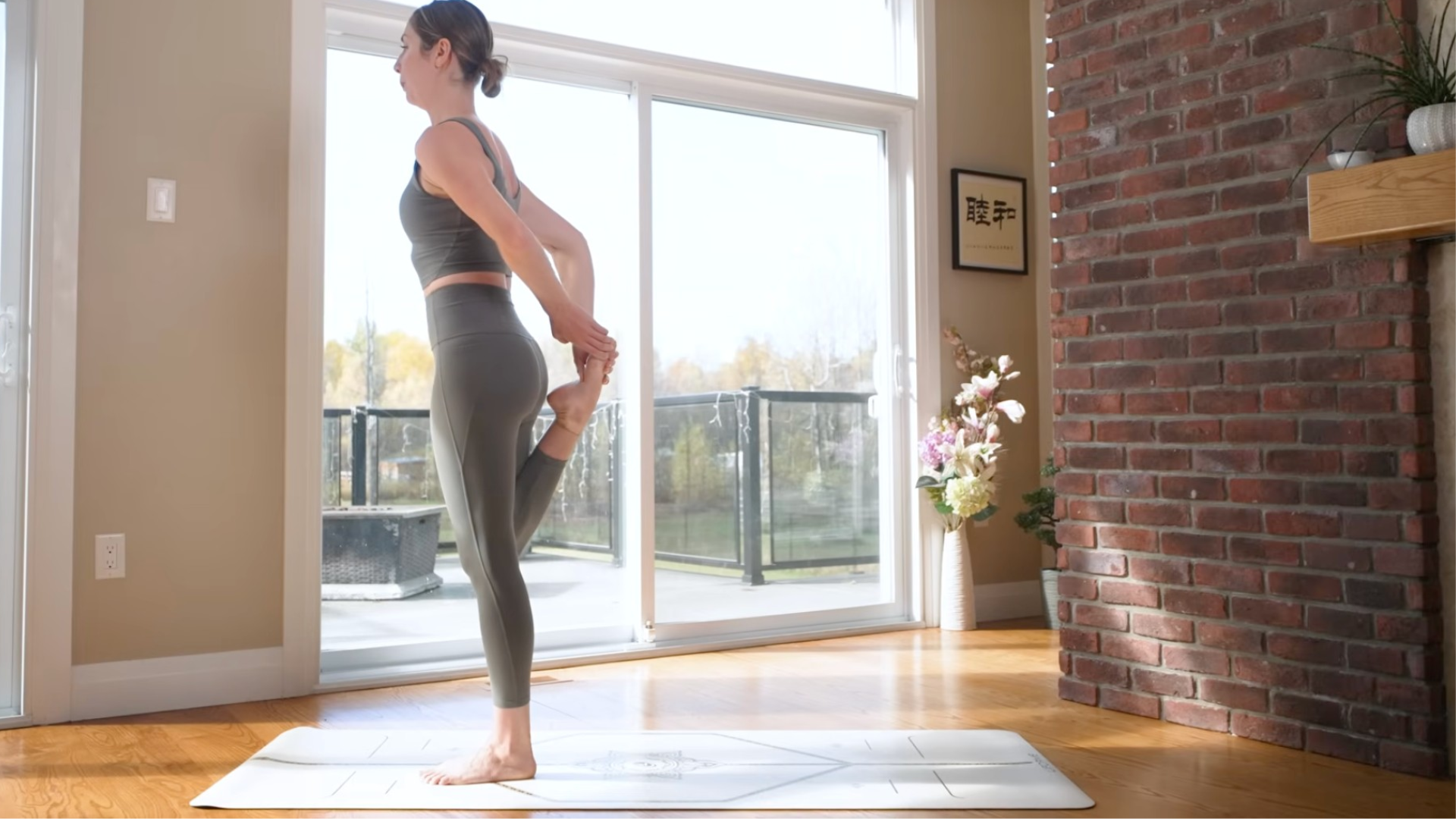 Woman bending her right knee and reaching behind with her hands to hold her right foot