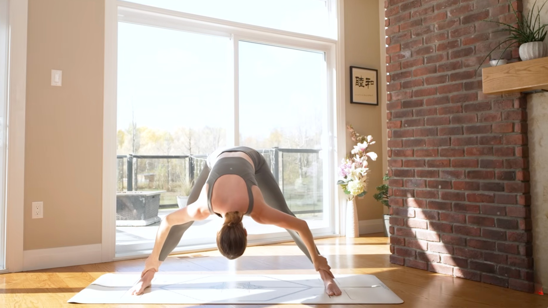 Woman leaning forward with her legs straight and her head reaching toward the mat