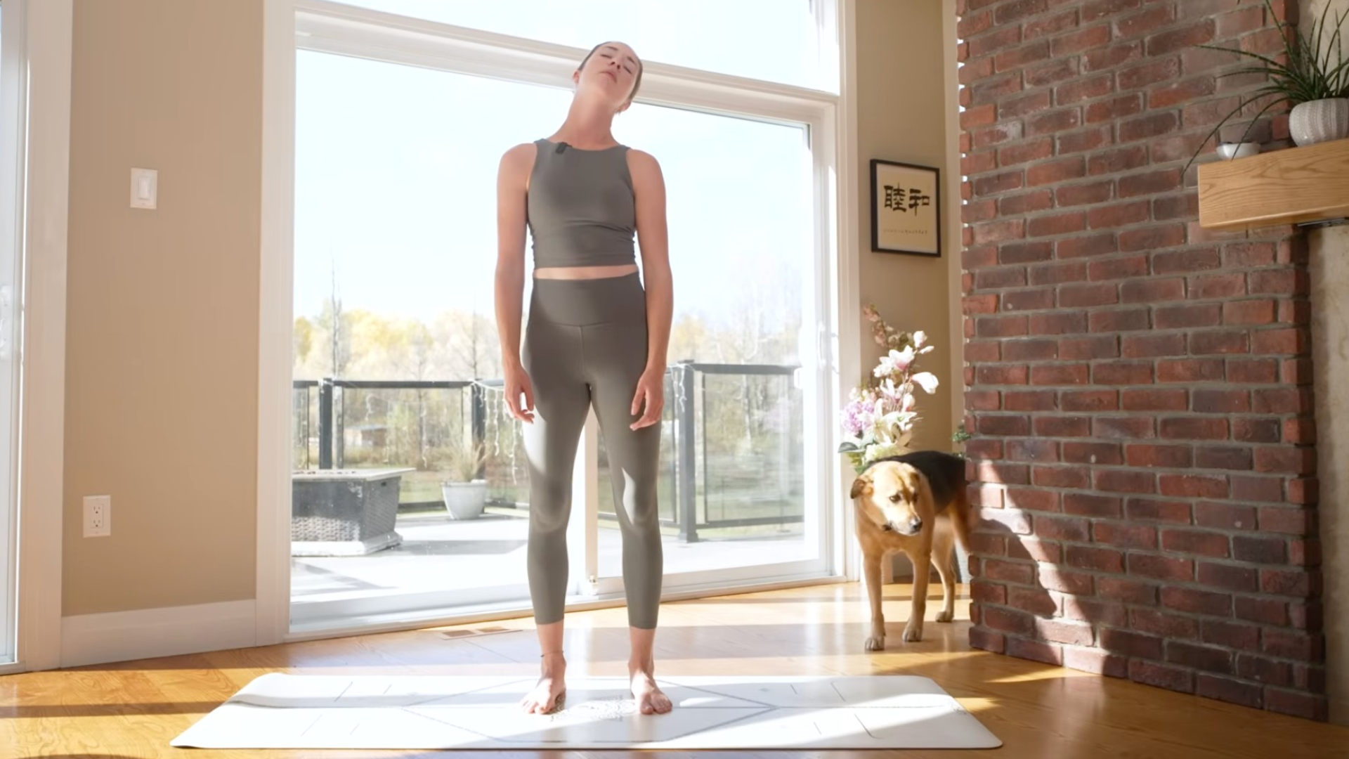 Woman on a yoga mat circling her neck in a stretch