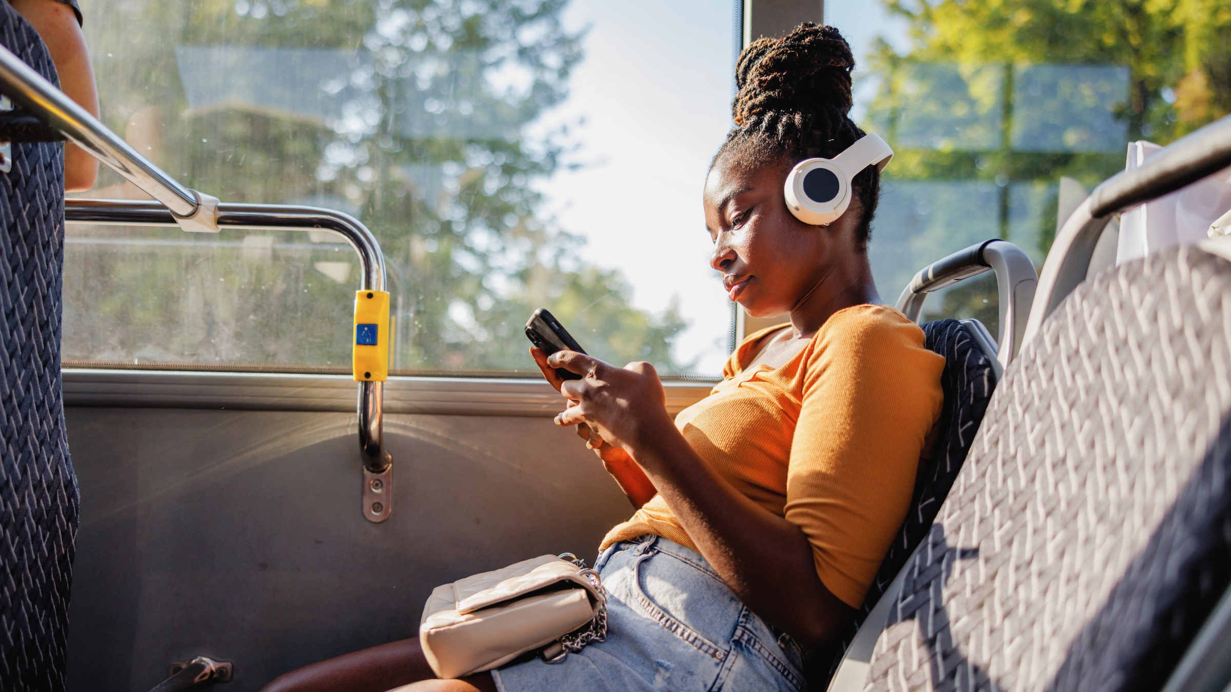 A woman using her phone on a bus